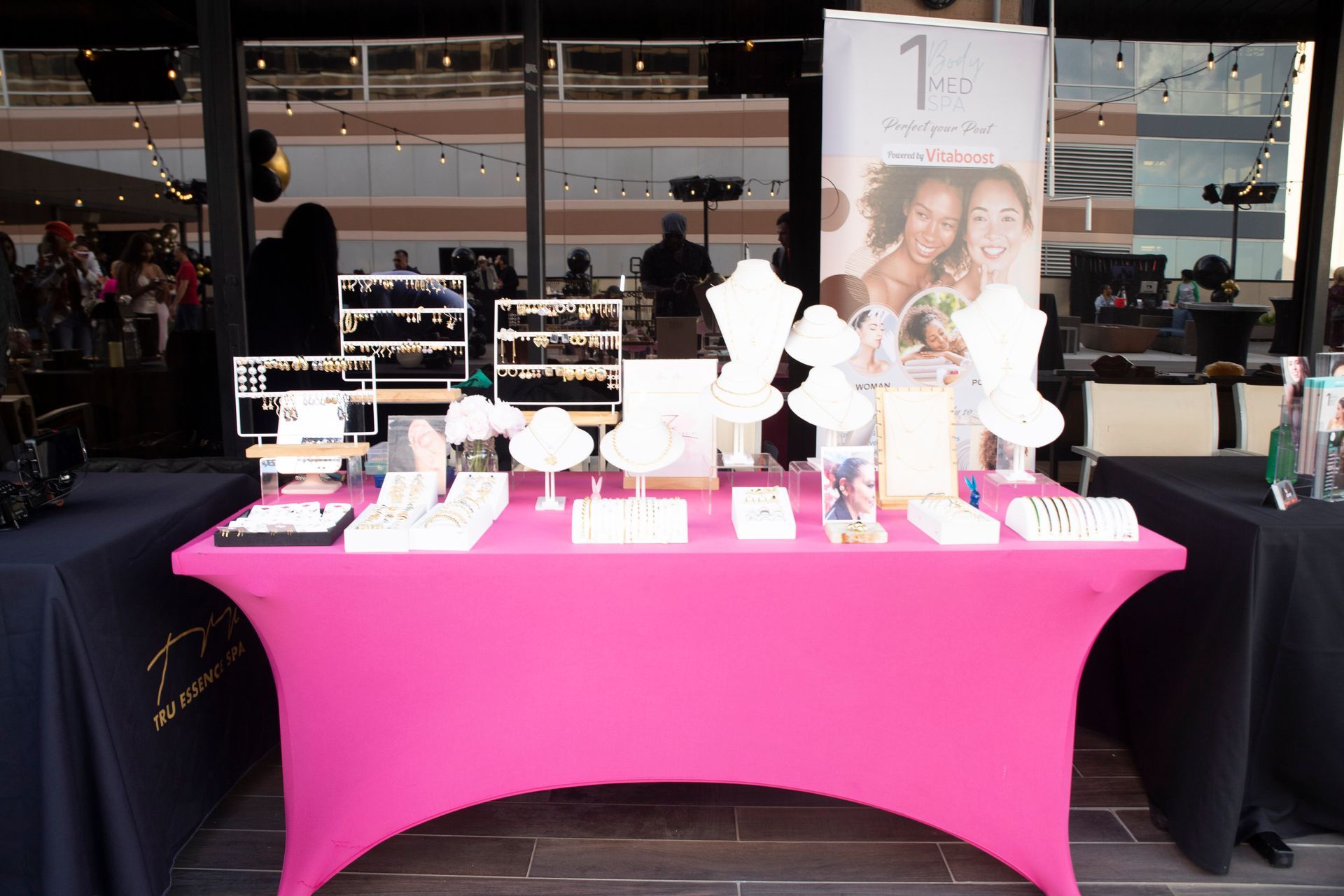 A table with a pink table cloth and jewelry on it