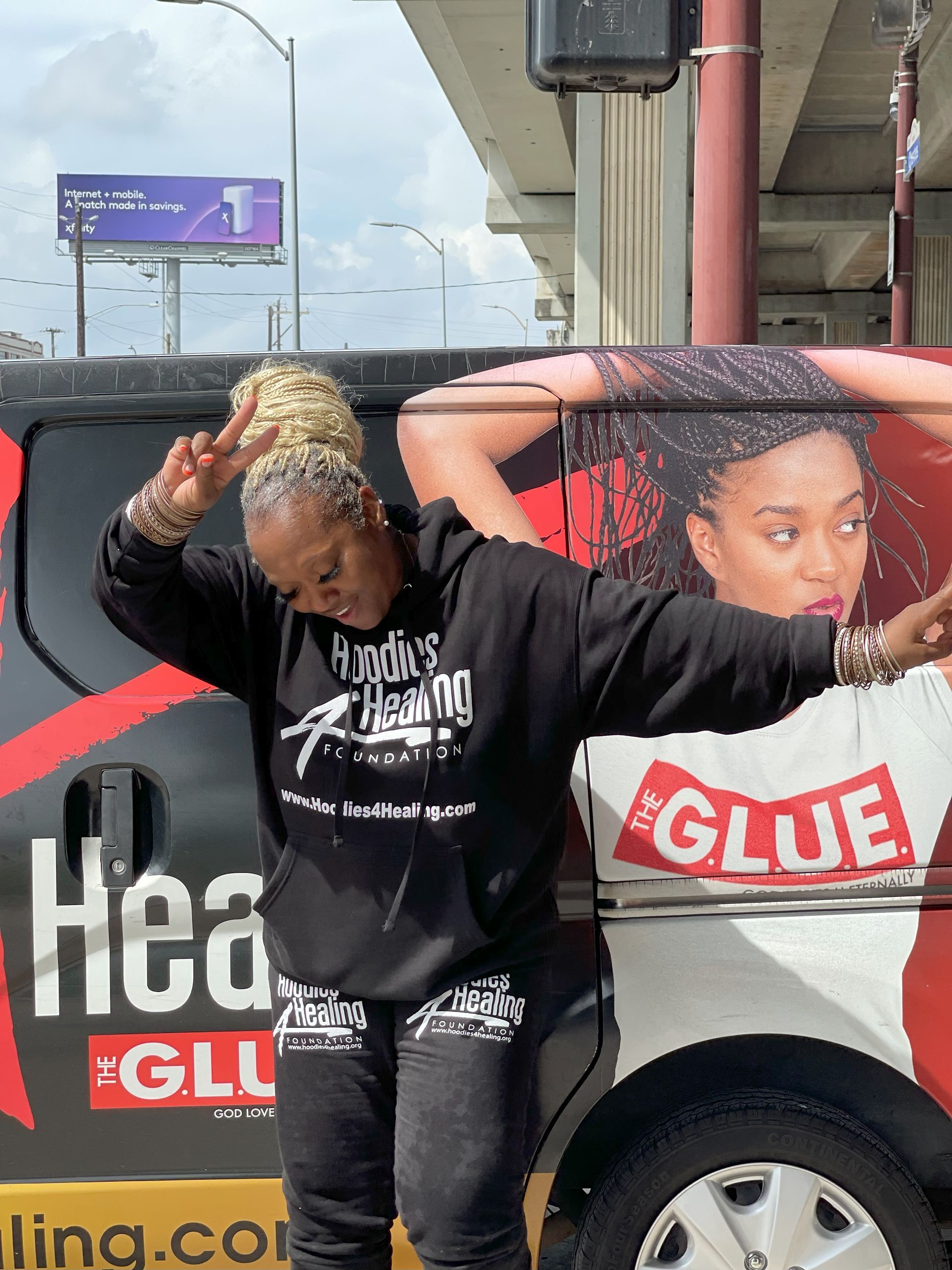 A woman standing in front of a van that says glue