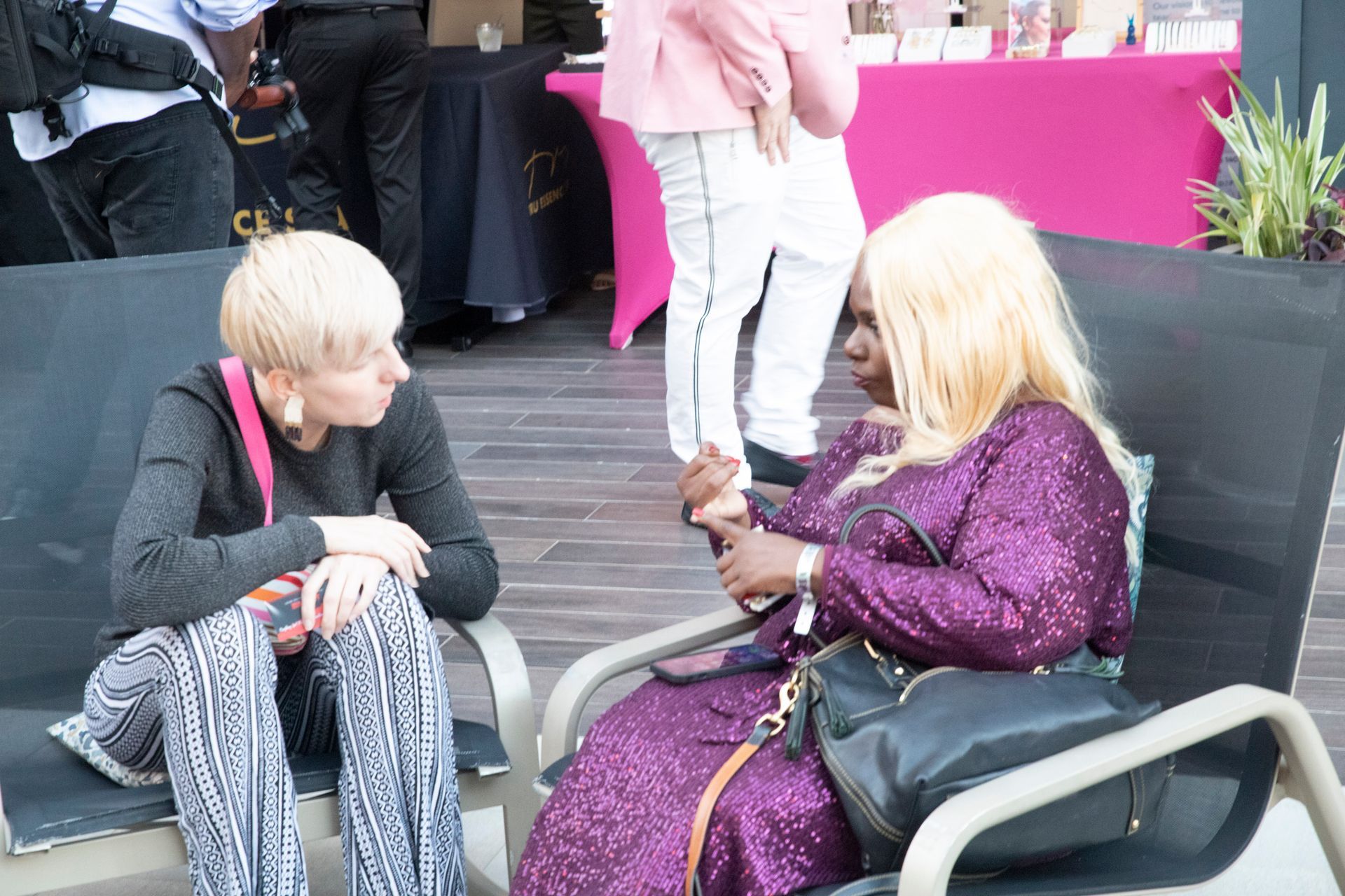 Two women are sitting on a bench talking to each other