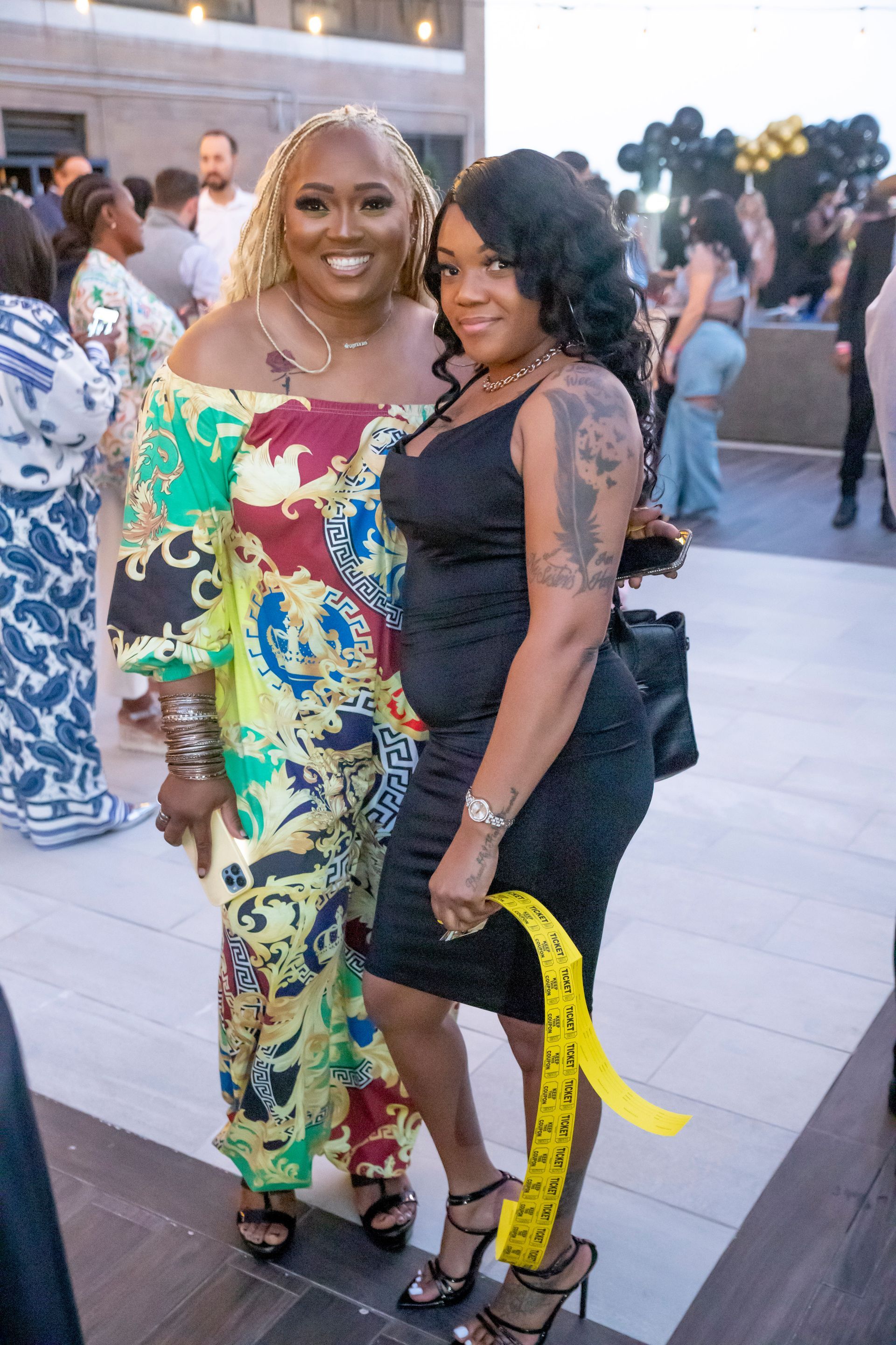 Two women are posing for a picture together at a party.