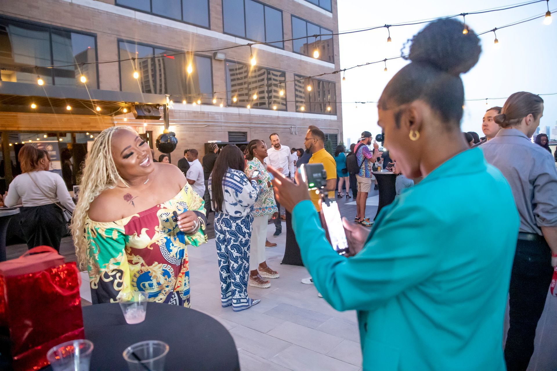 A woman is taking a picture of another woman at a party.