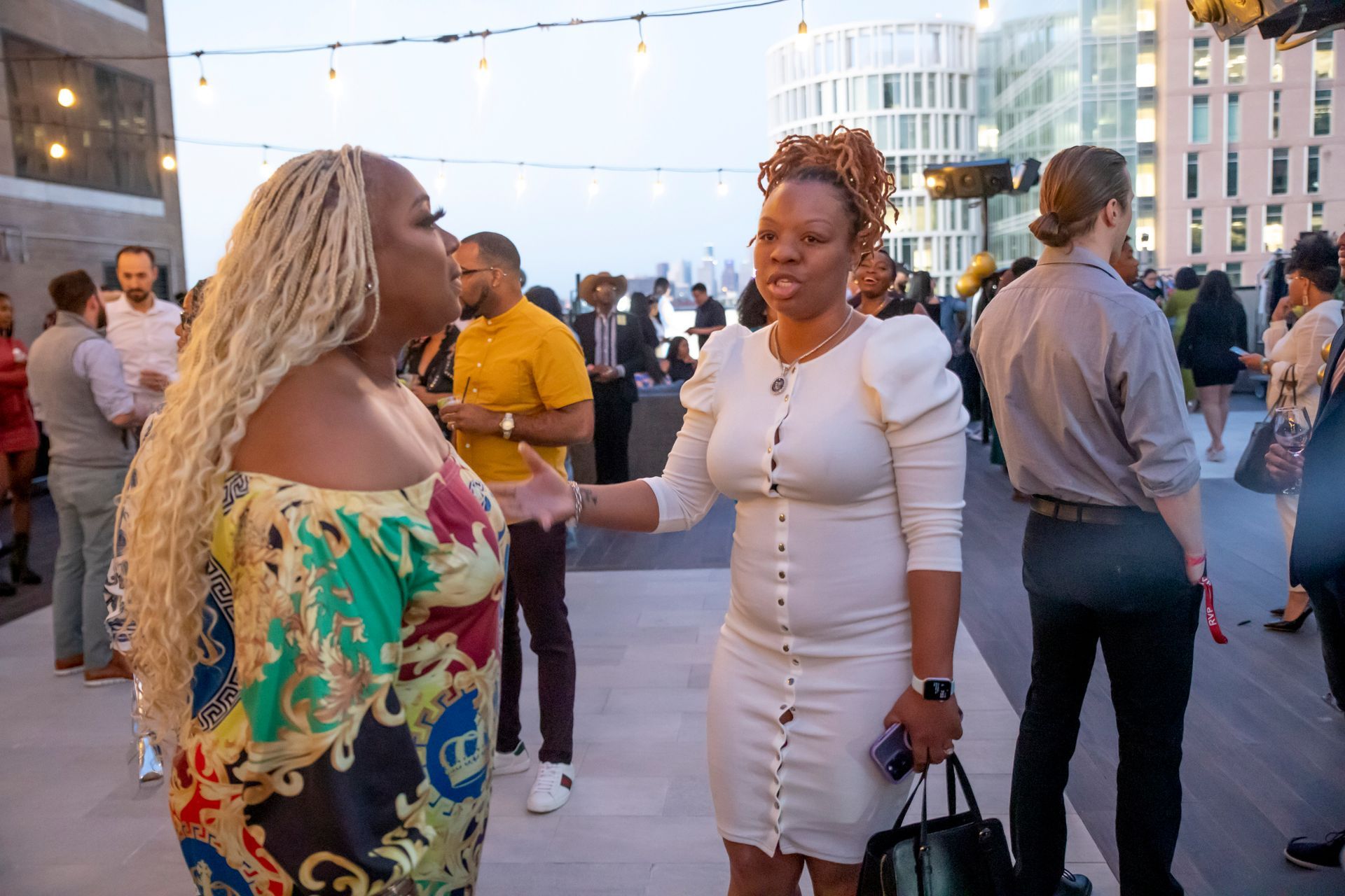 Two women are standing next to each other in a crowd of people.