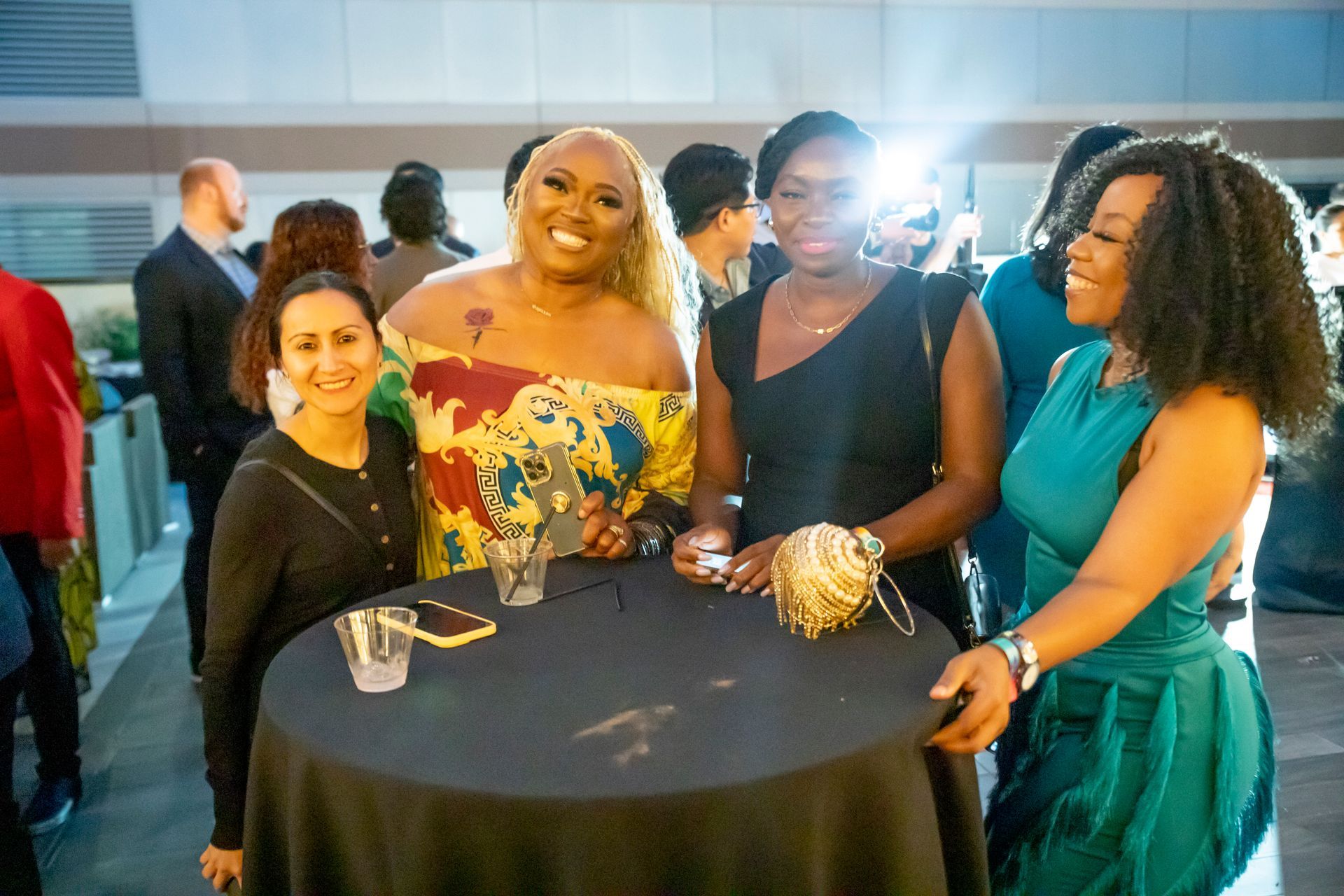 A group of women are standing around a table at a party.