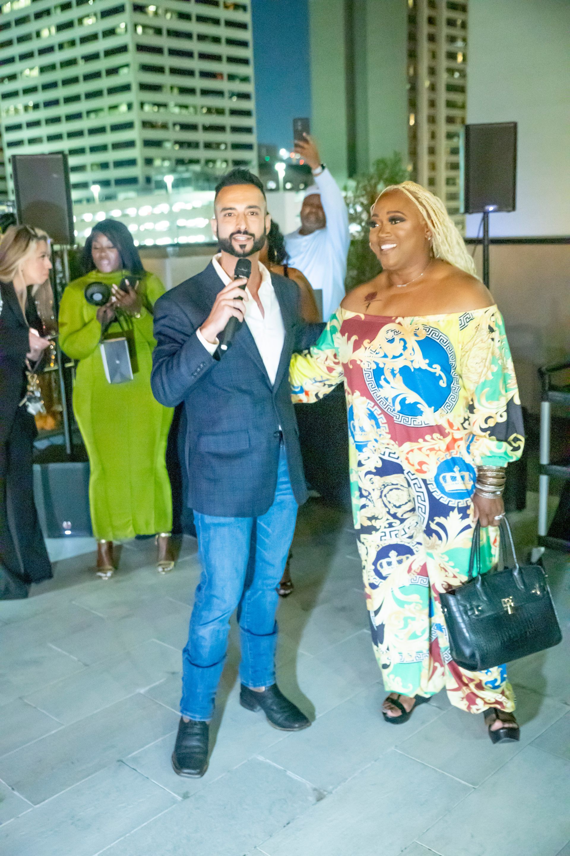 A man is holding a microphone while standing next to a woman.