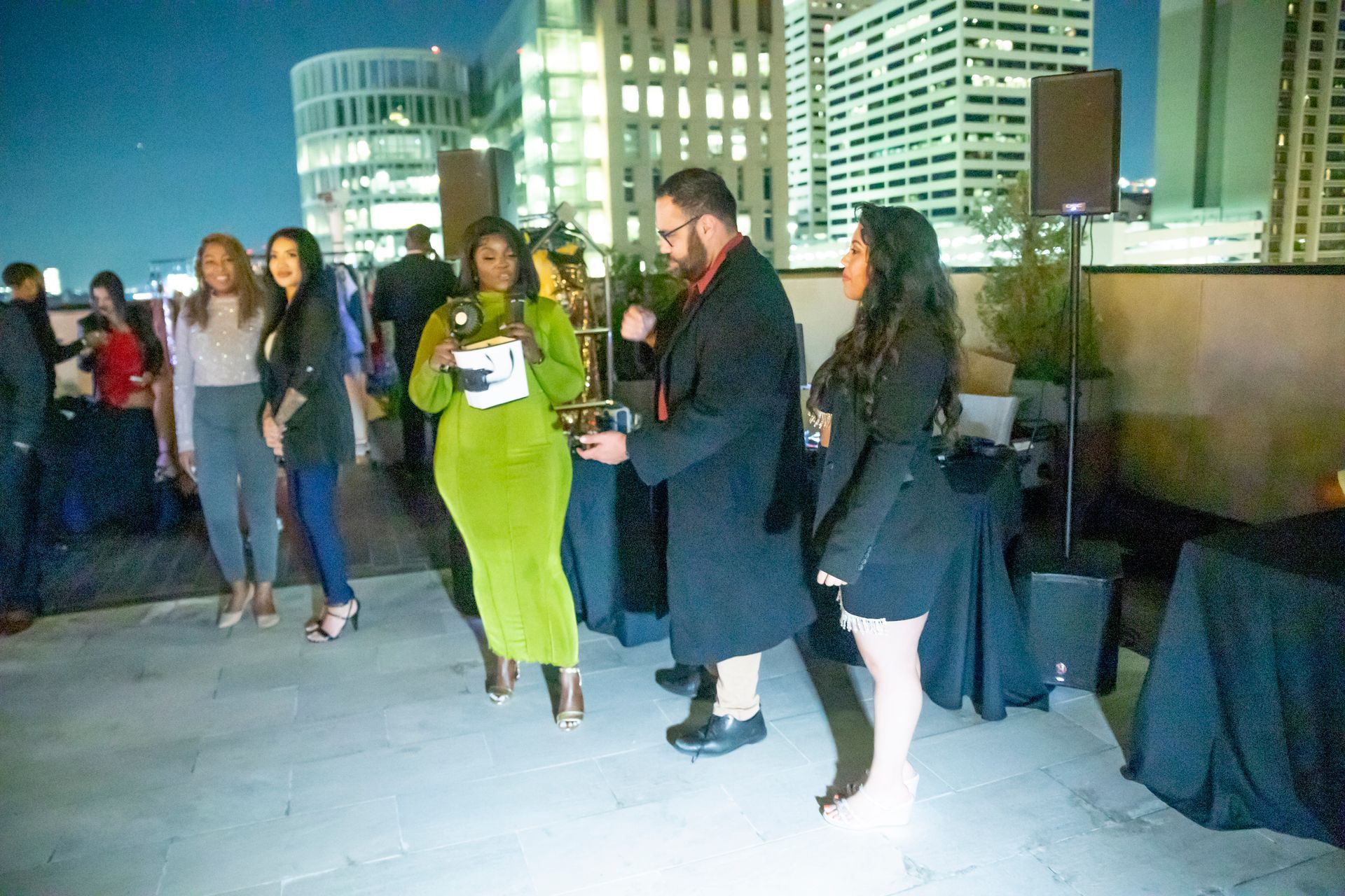 A group of people are standing on a rooftop at night.