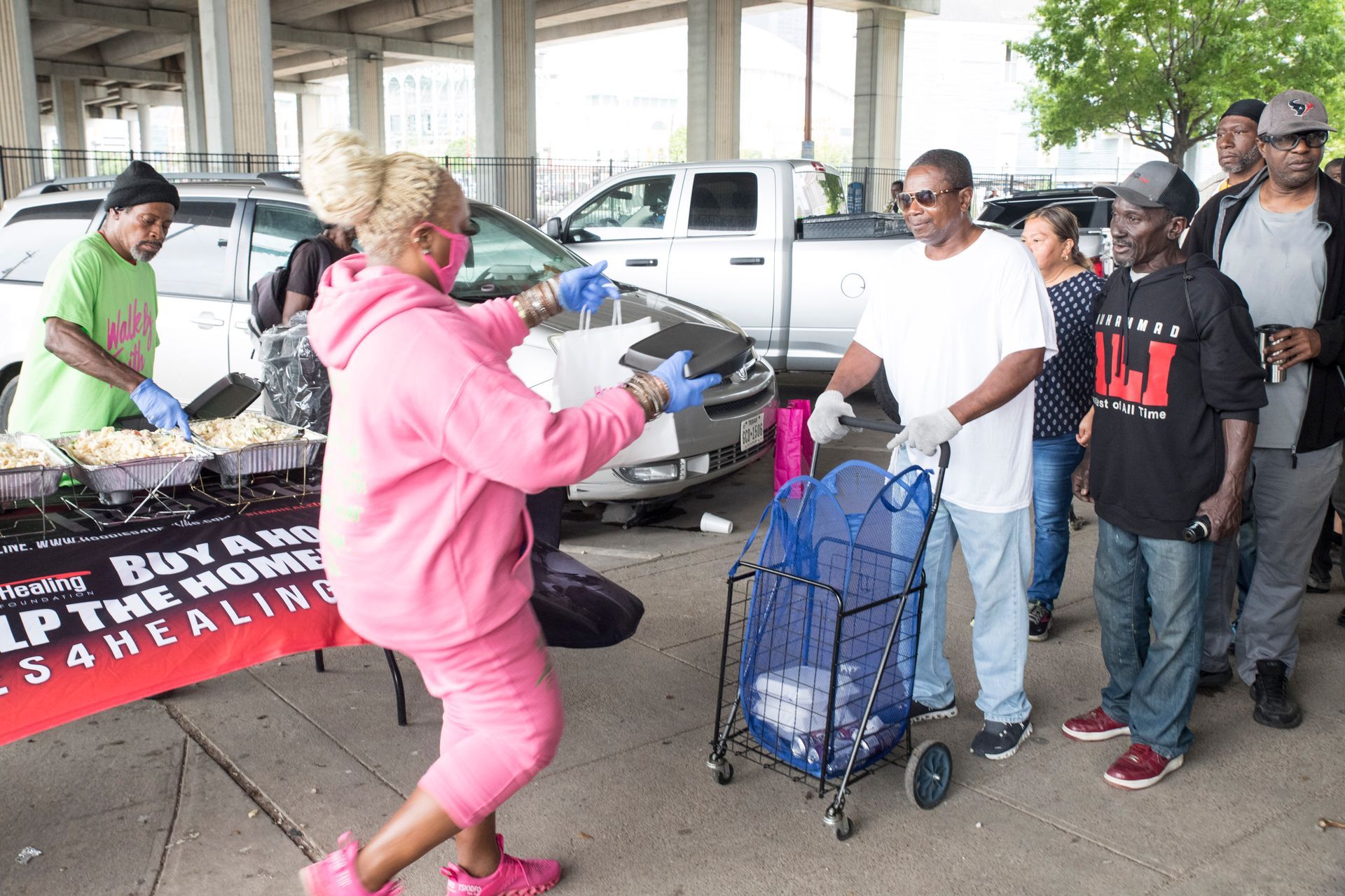 A group of people are standing around a table that says buy a home