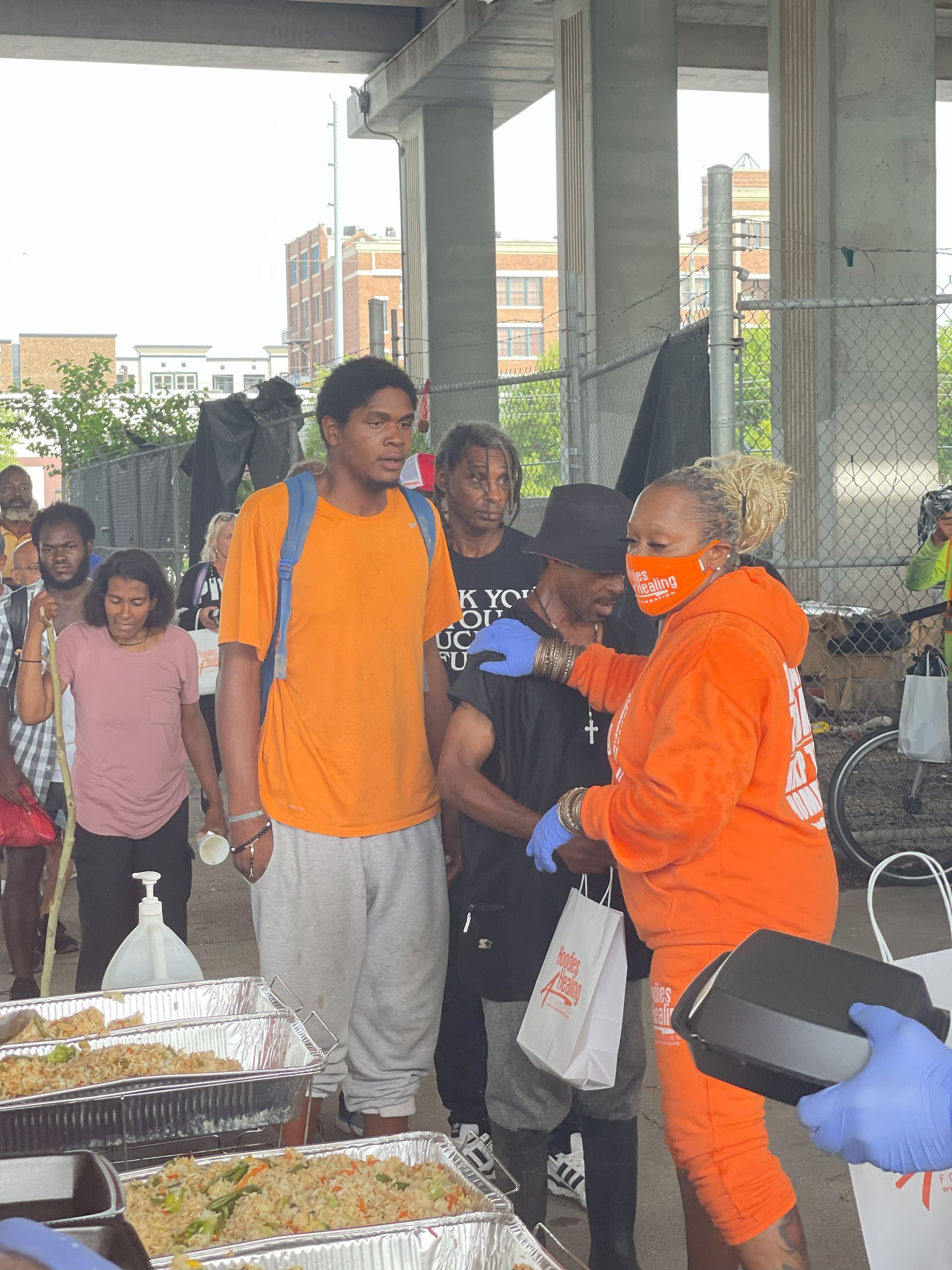 A group of people standing around a table with food