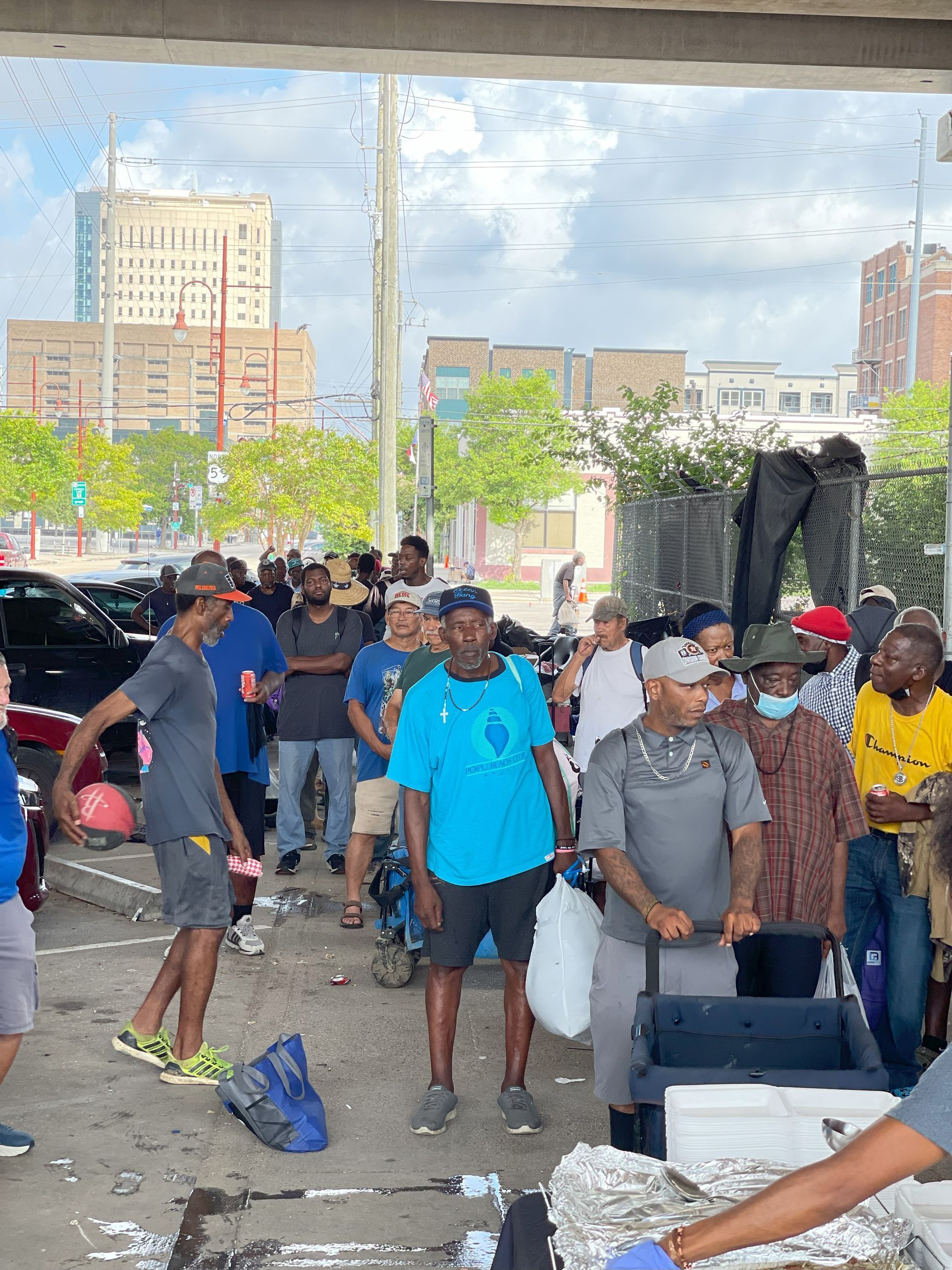 A group of people are standing in a parking lot.