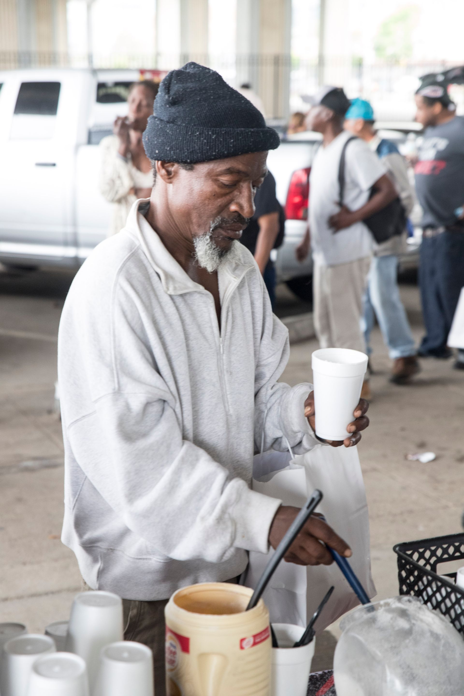 A man is making a drink with a pitcher and a spoon