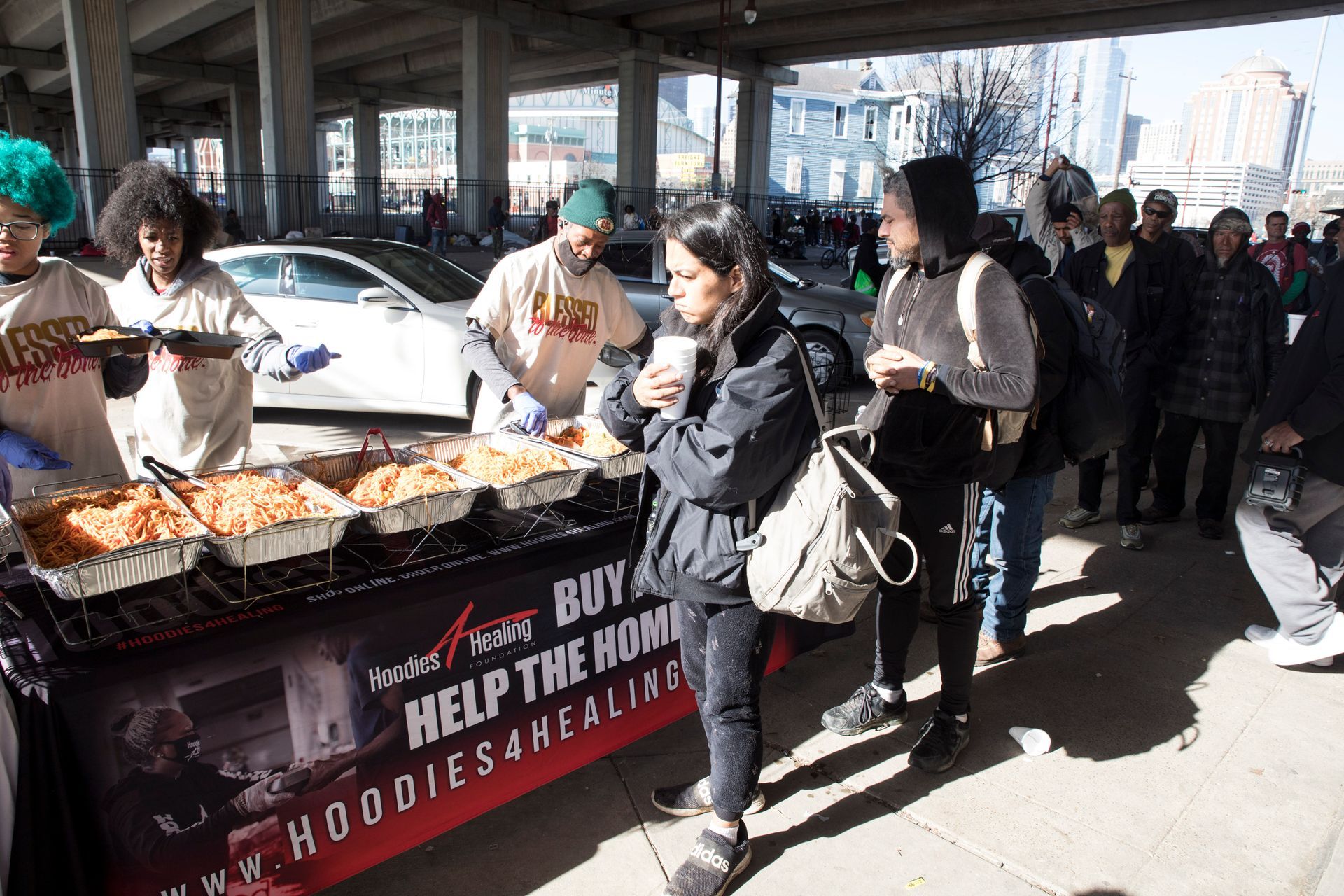A group of people standing around a table that says help the home
