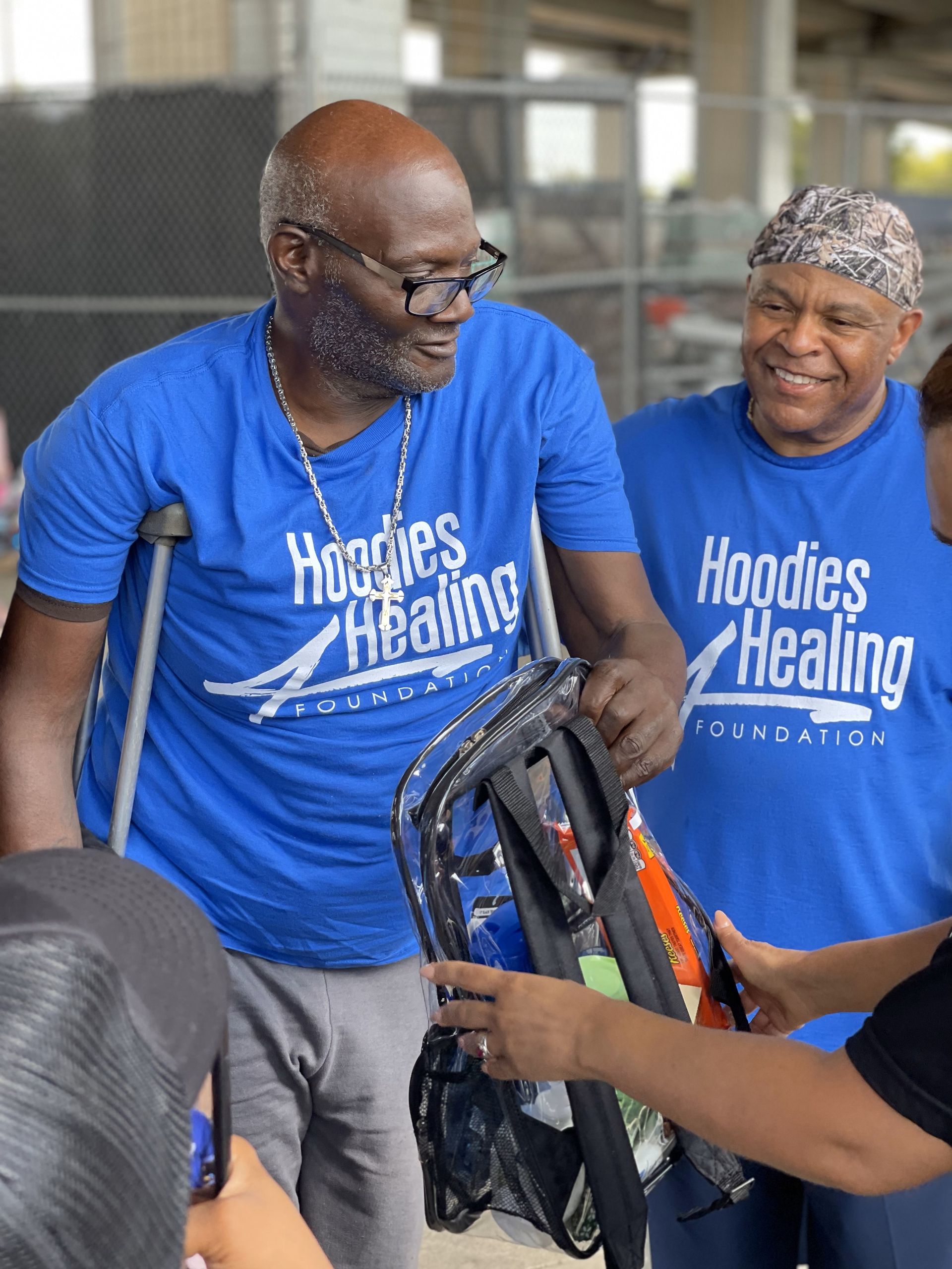 A man wearing a blue shirt that says hoodies healing