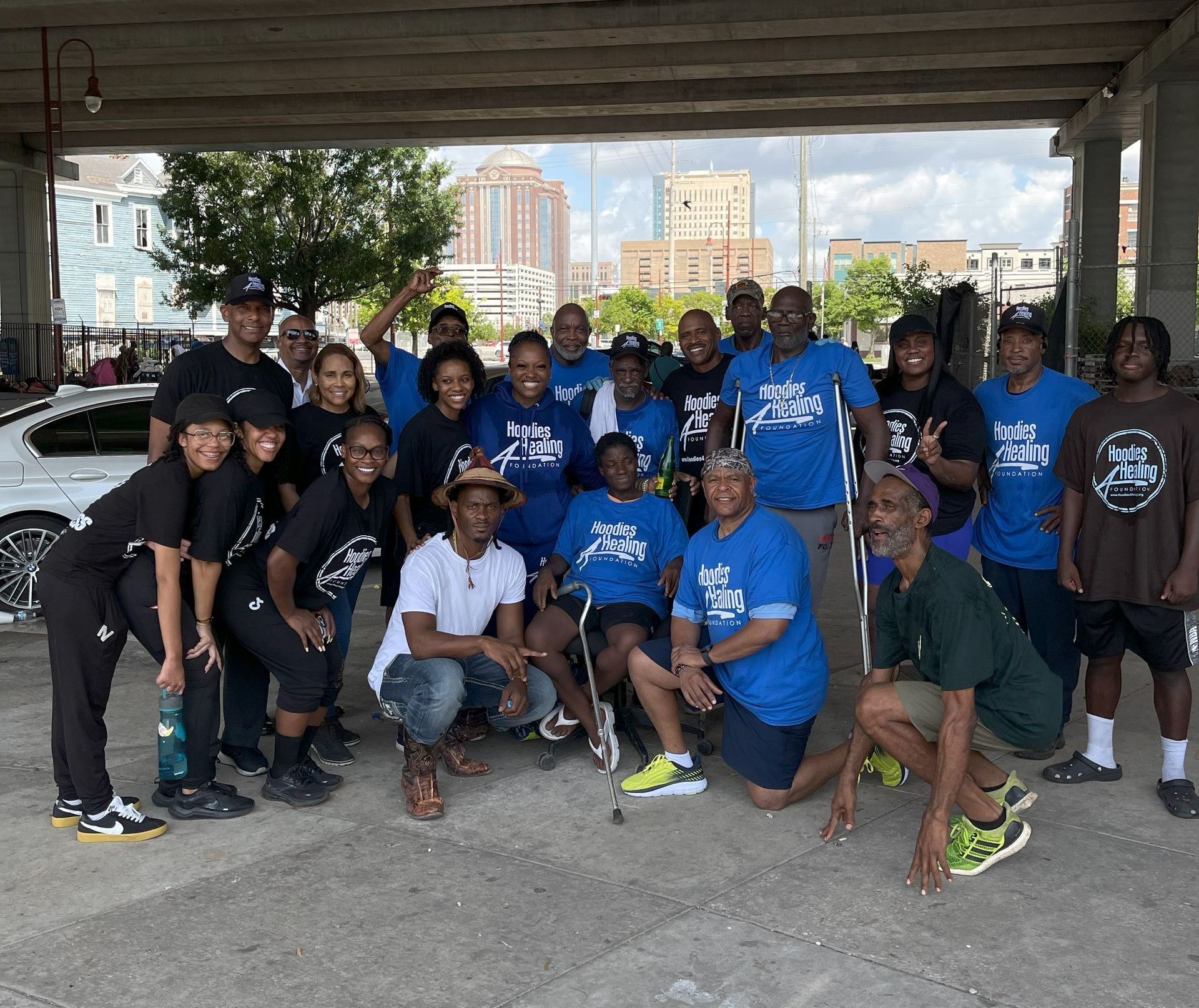 A group of people are posing for a picture under a bridge.