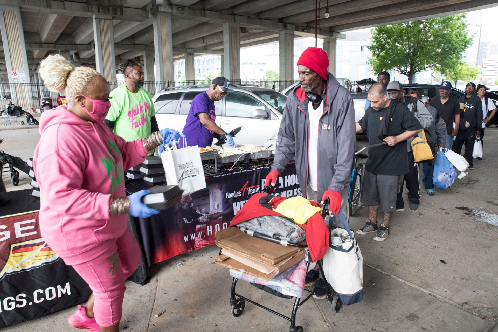 A group of people are standing around a table in a parking lot.