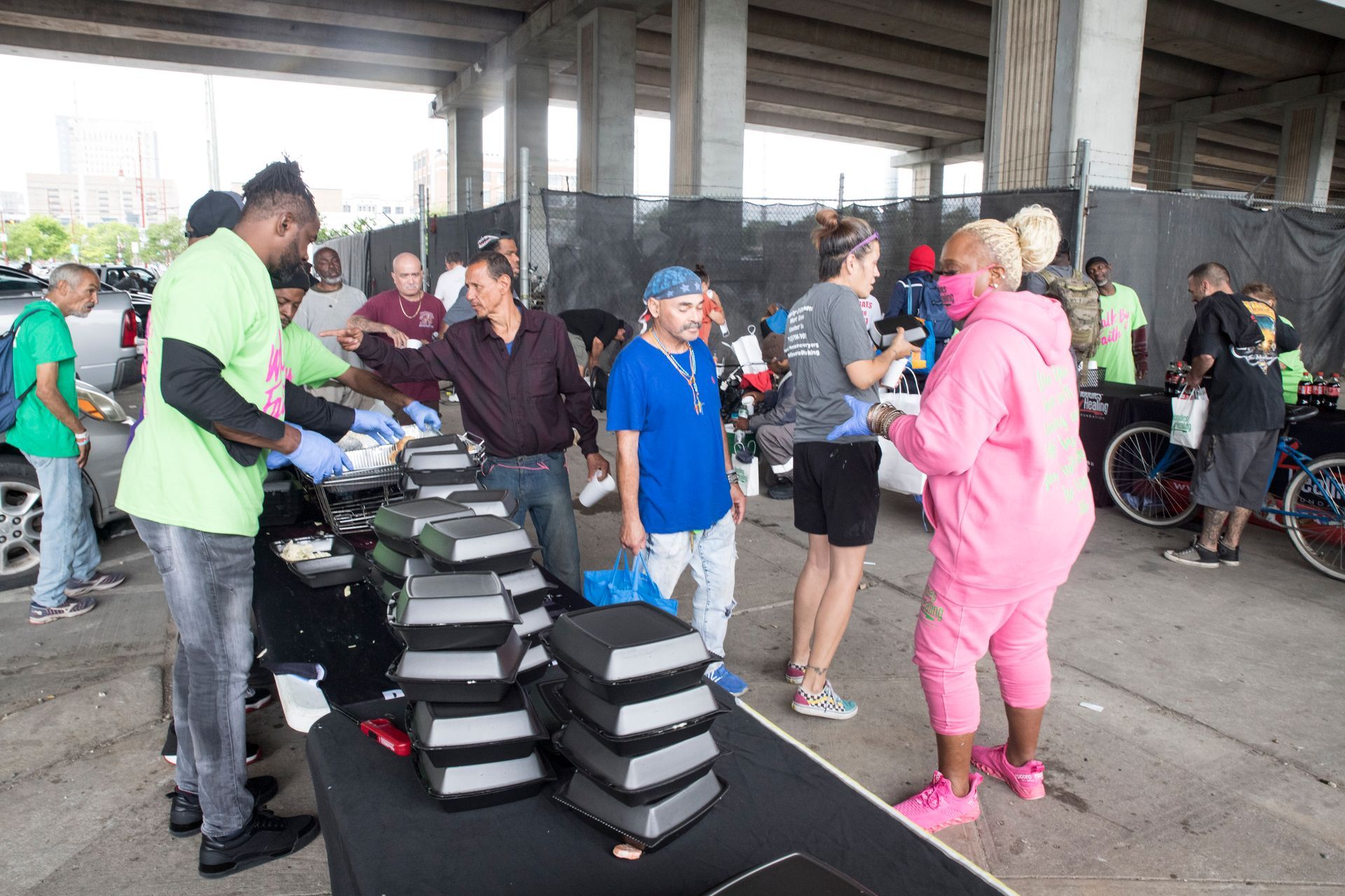 A group of people are standing around a table with stacks of books on it.