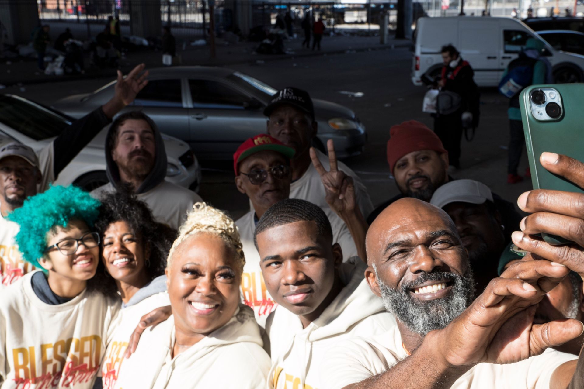 A group of people are taking a selfie with a cell phone.