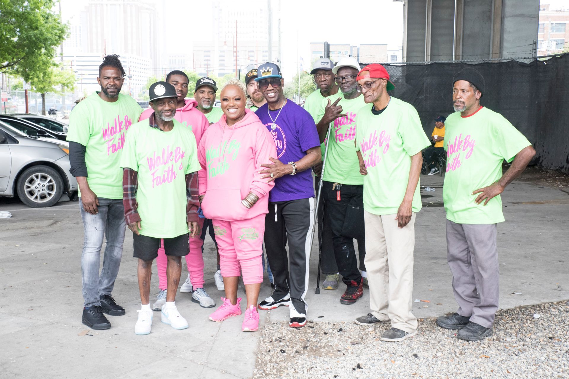 A group of people are posing for a picture in a parking lot.