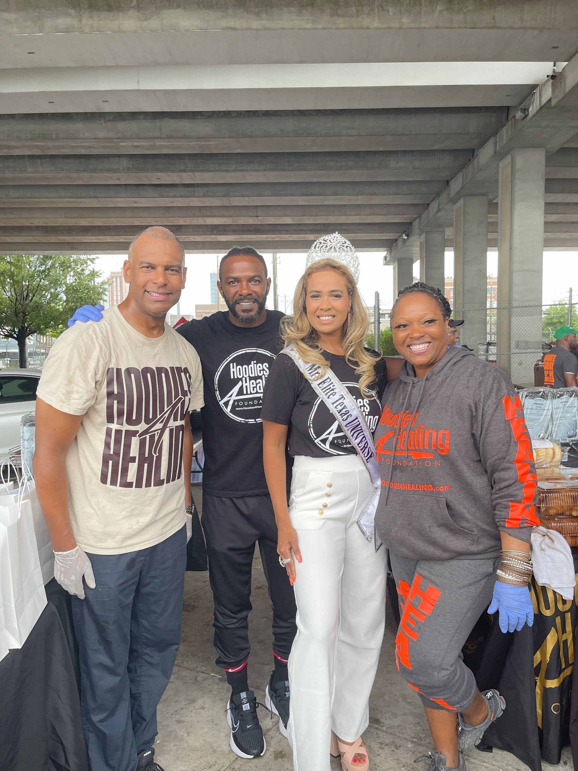 A group of people are posing for a picture in a parking garage.