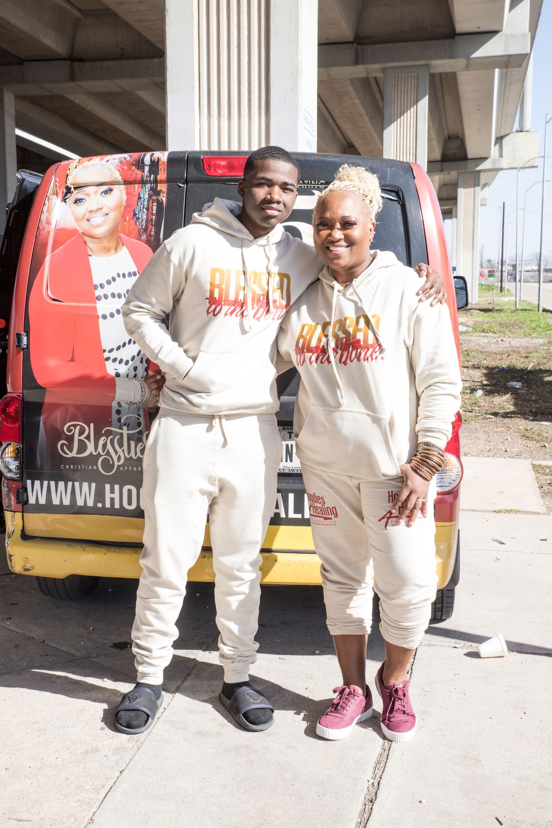 A man and a woman are posing for a picture in front of a van.
