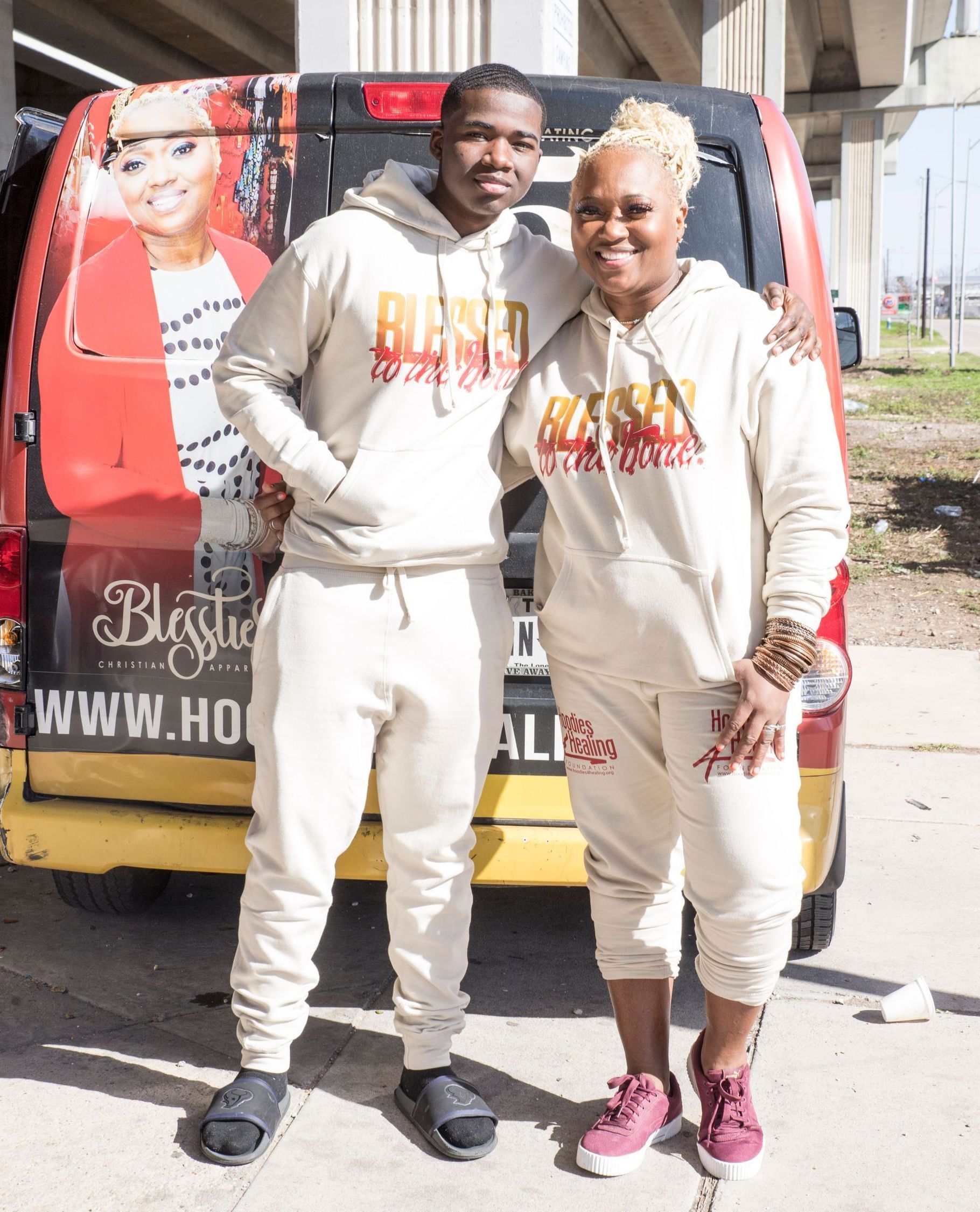 A man and a woman are posing for a picture in front of a van.