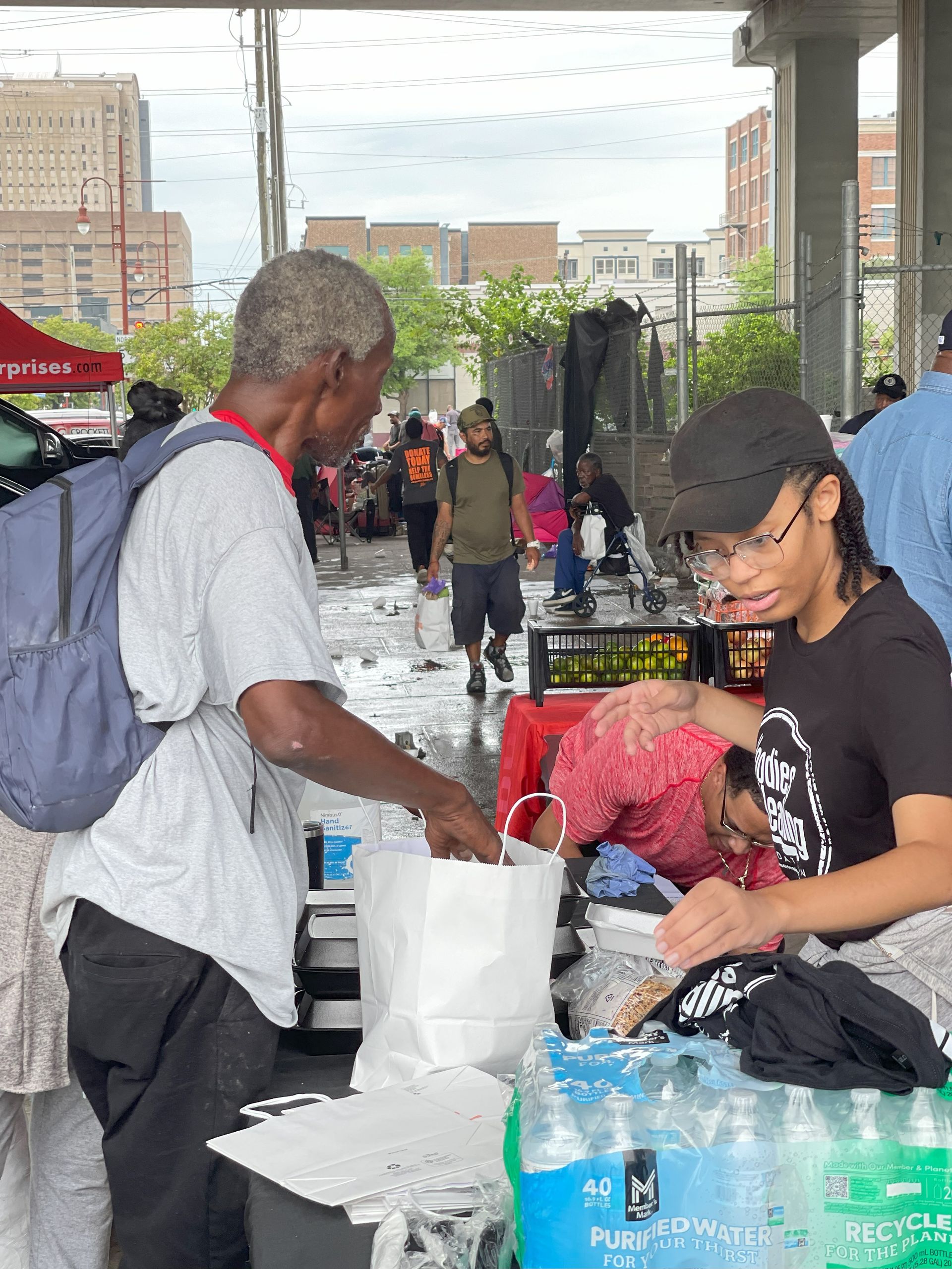 A man is giving a bag of food to a woman.