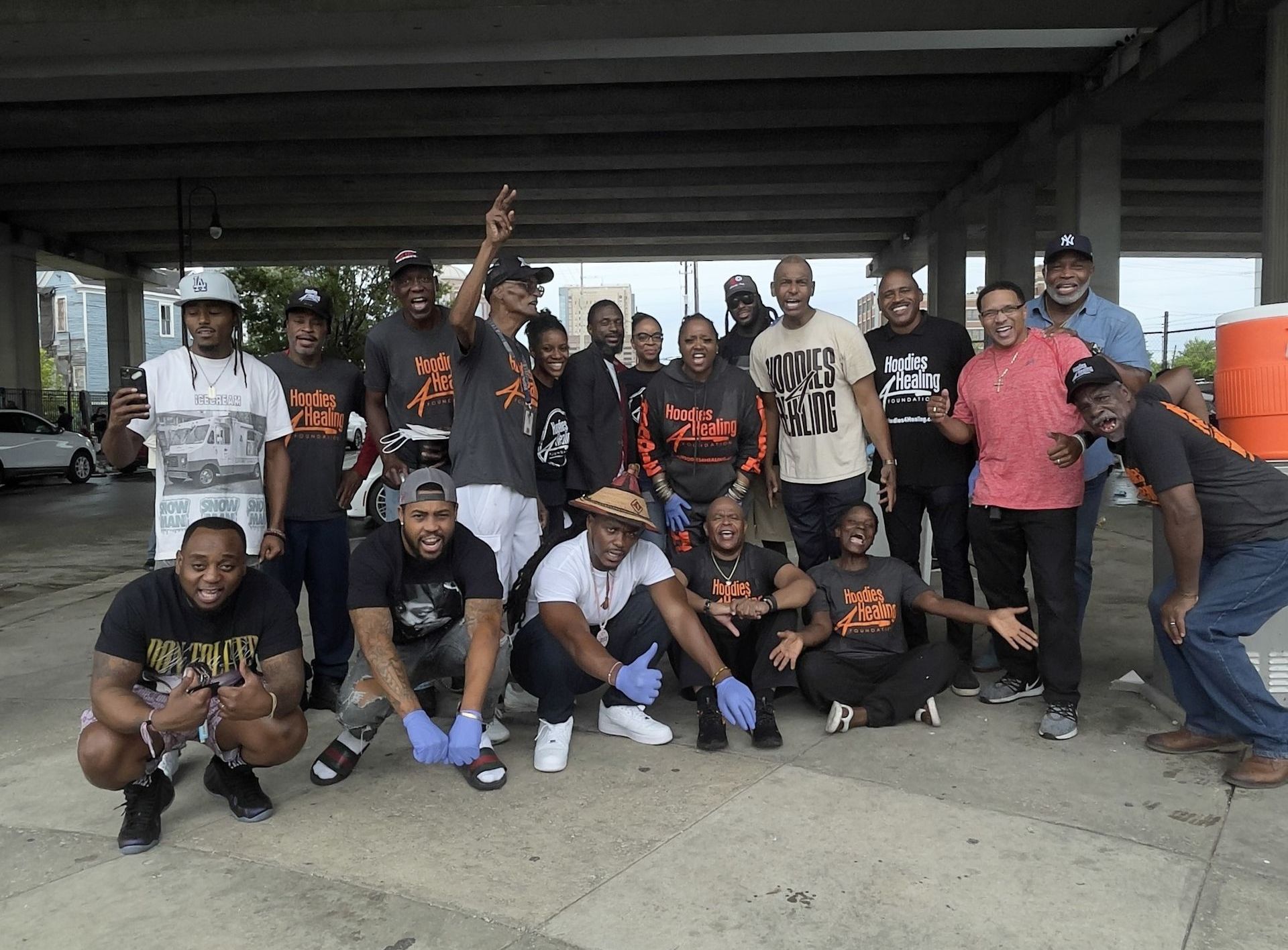 A group of young men are posing for a picture under a bridge.