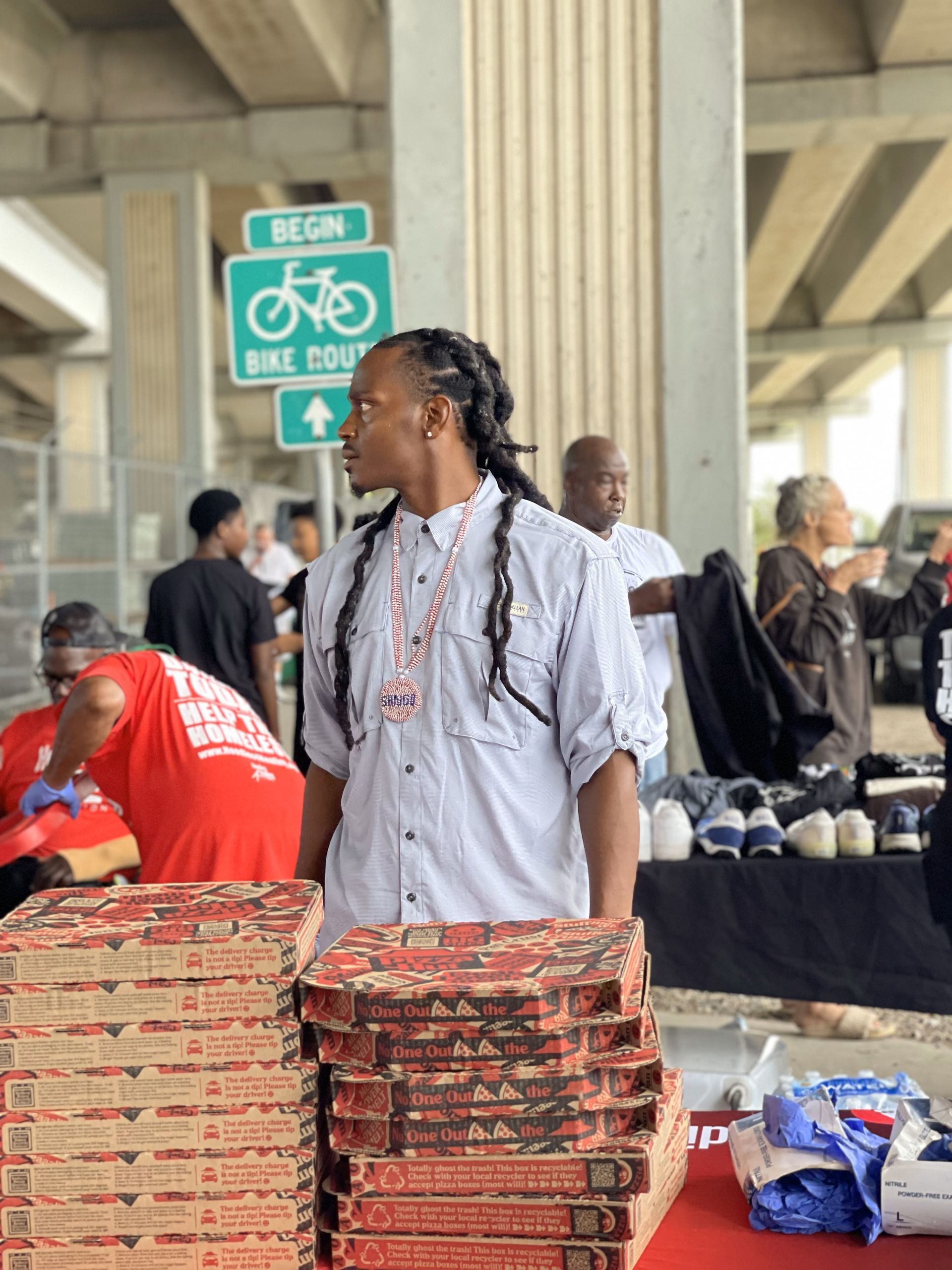 A man standing in front of a stack of pizza boxes