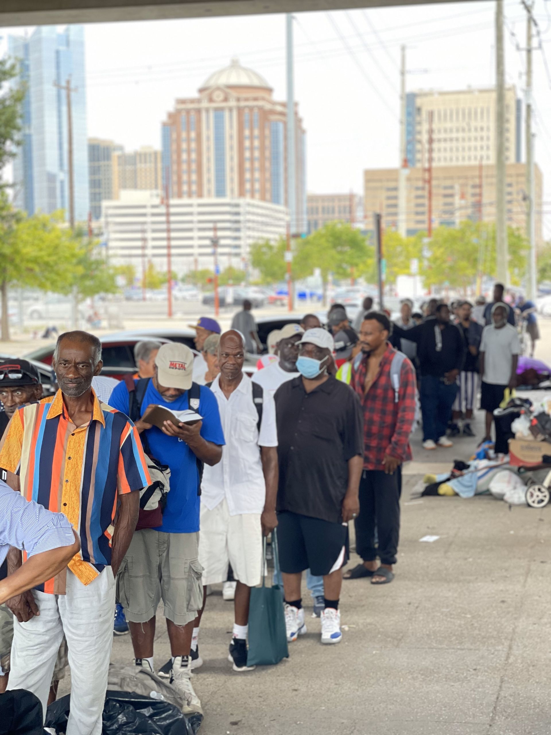 A group of men standing in a line with one wearing a nasa hat