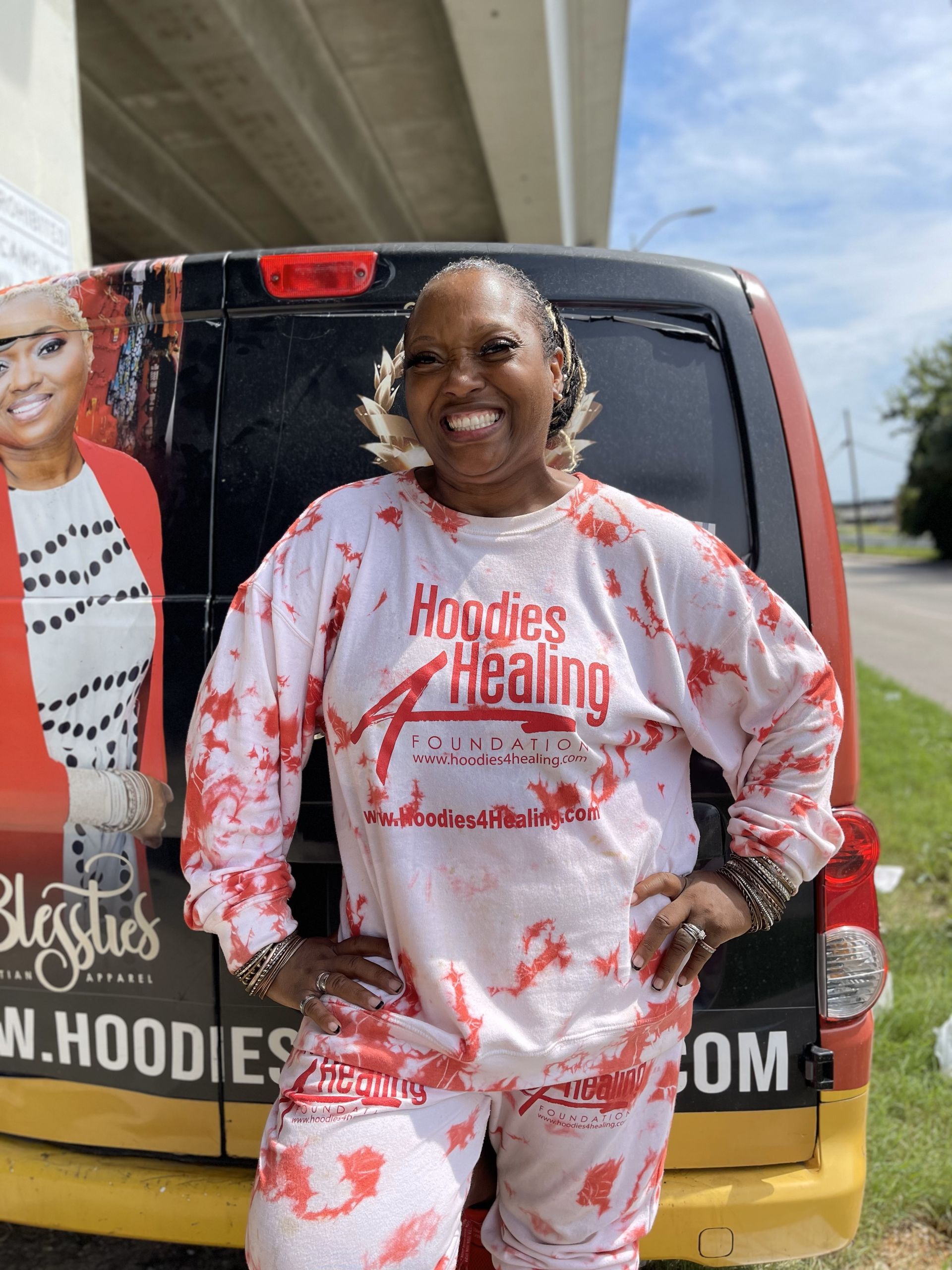 A woman is standing in front of a hoodies healing van