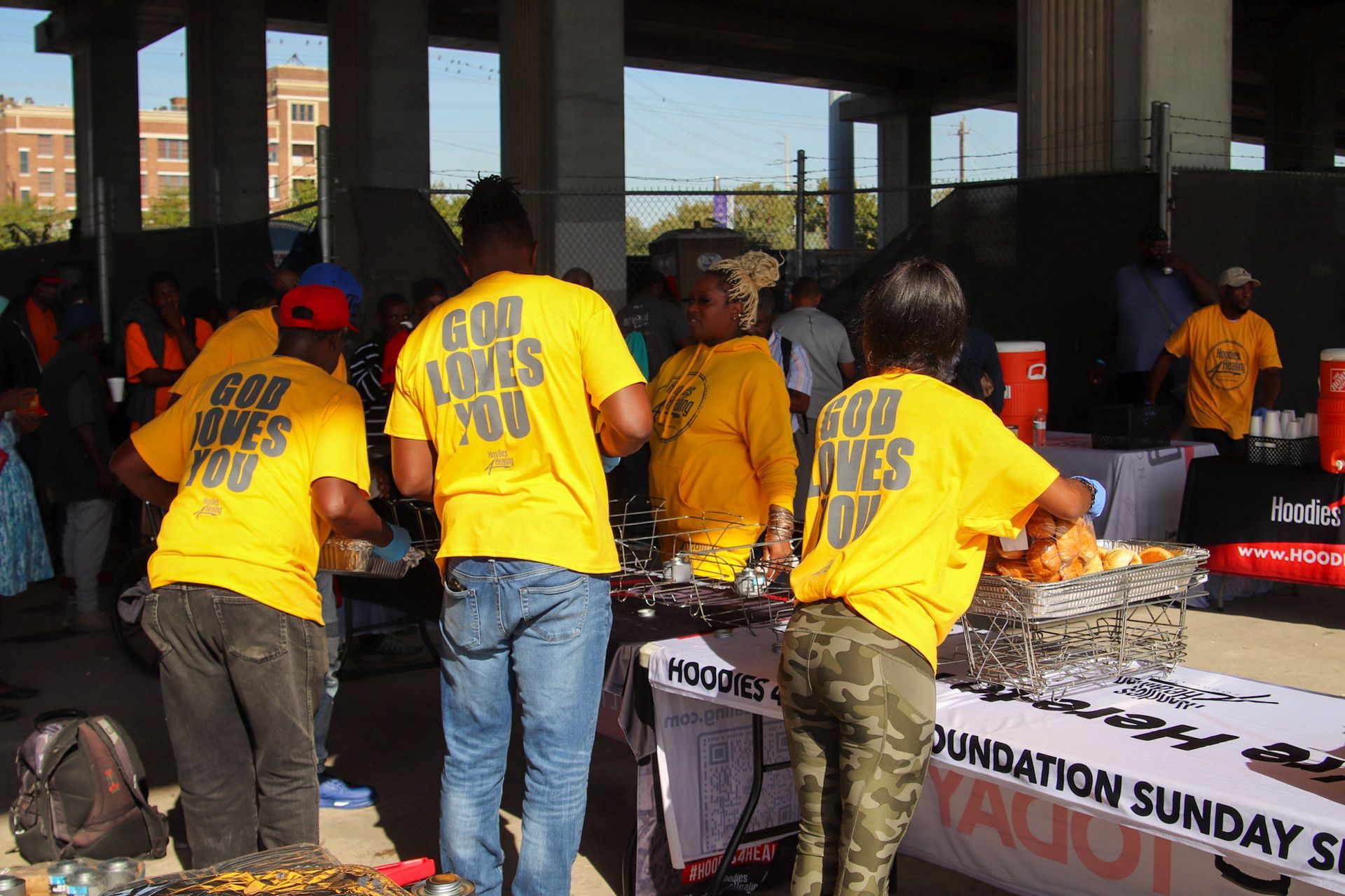A group of people wearing yellow shirts that say god loves you