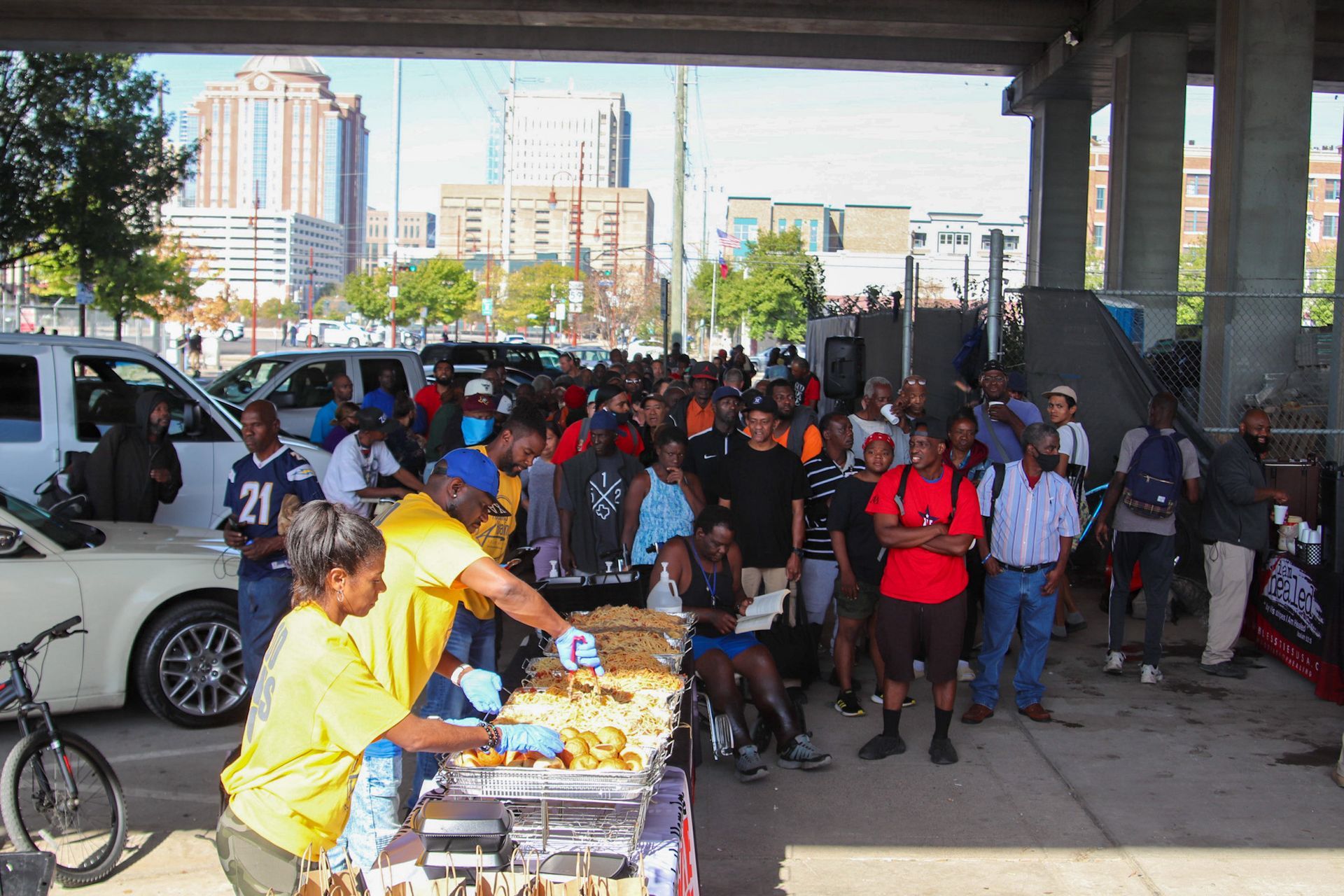 A group of people are standing around a table with food and one of them has the number 21 on his shirt