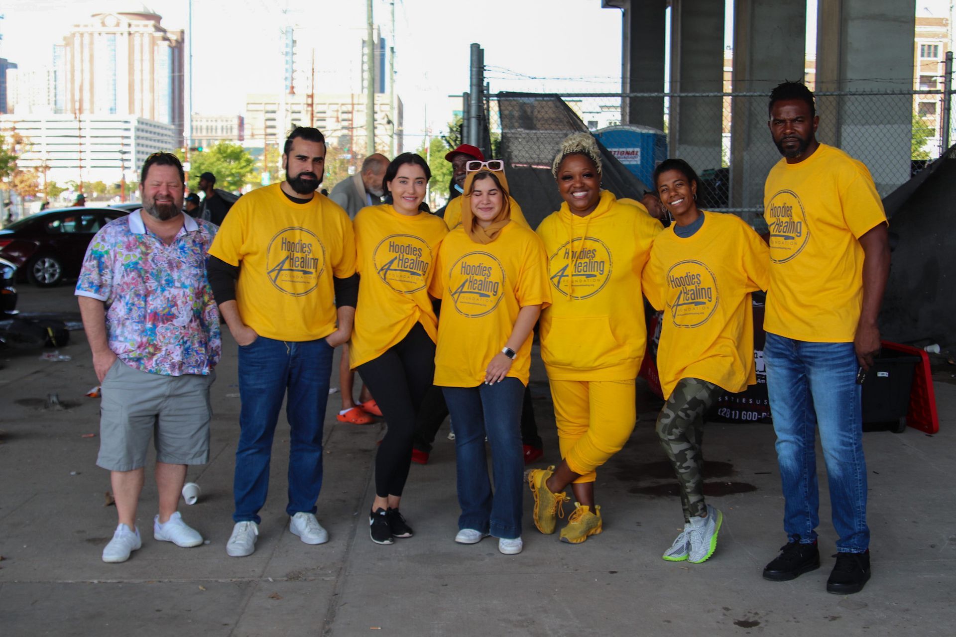 A group of people wearing yellow shirts are posing for a picture.
