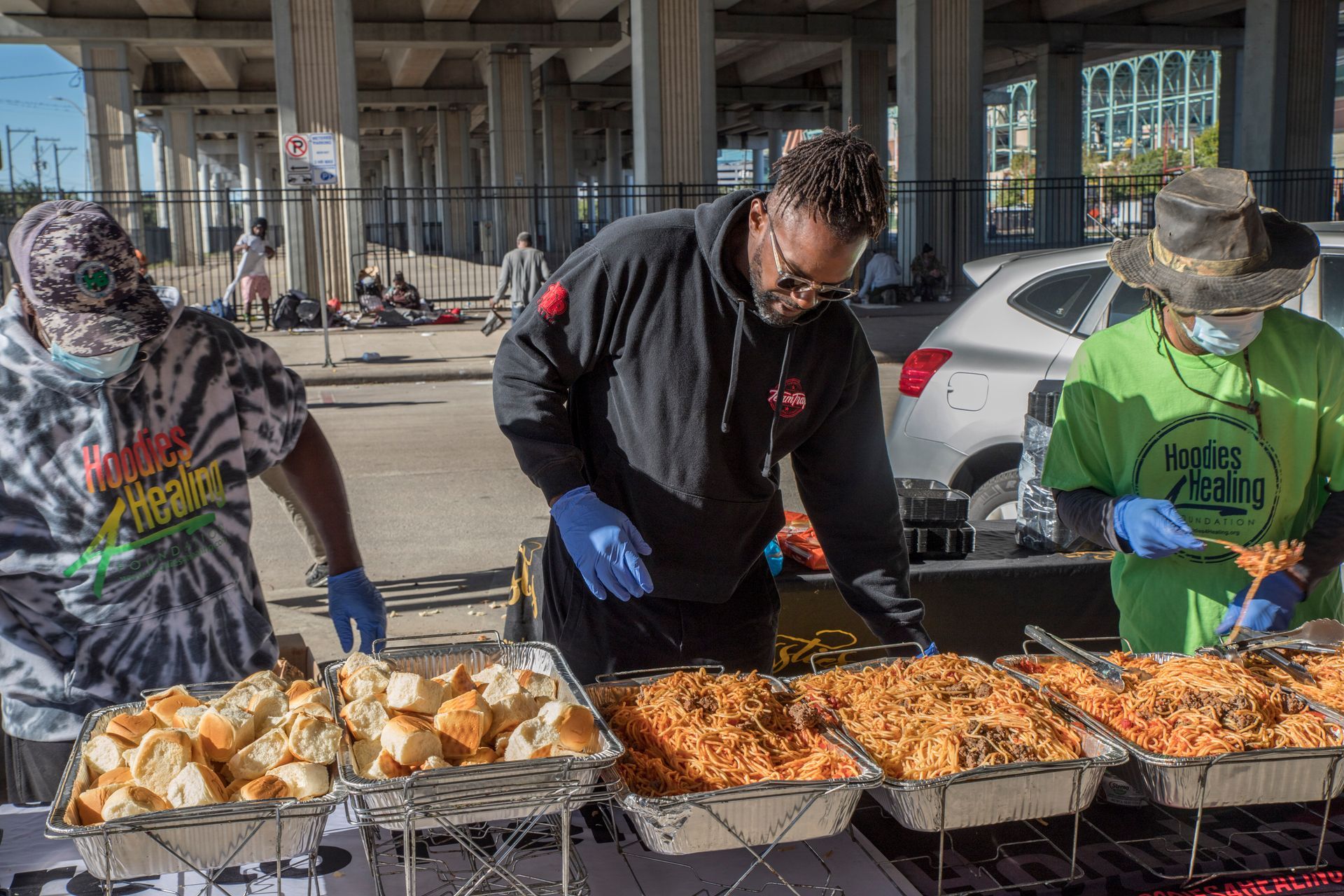 A group of people are standing around a table serving food.