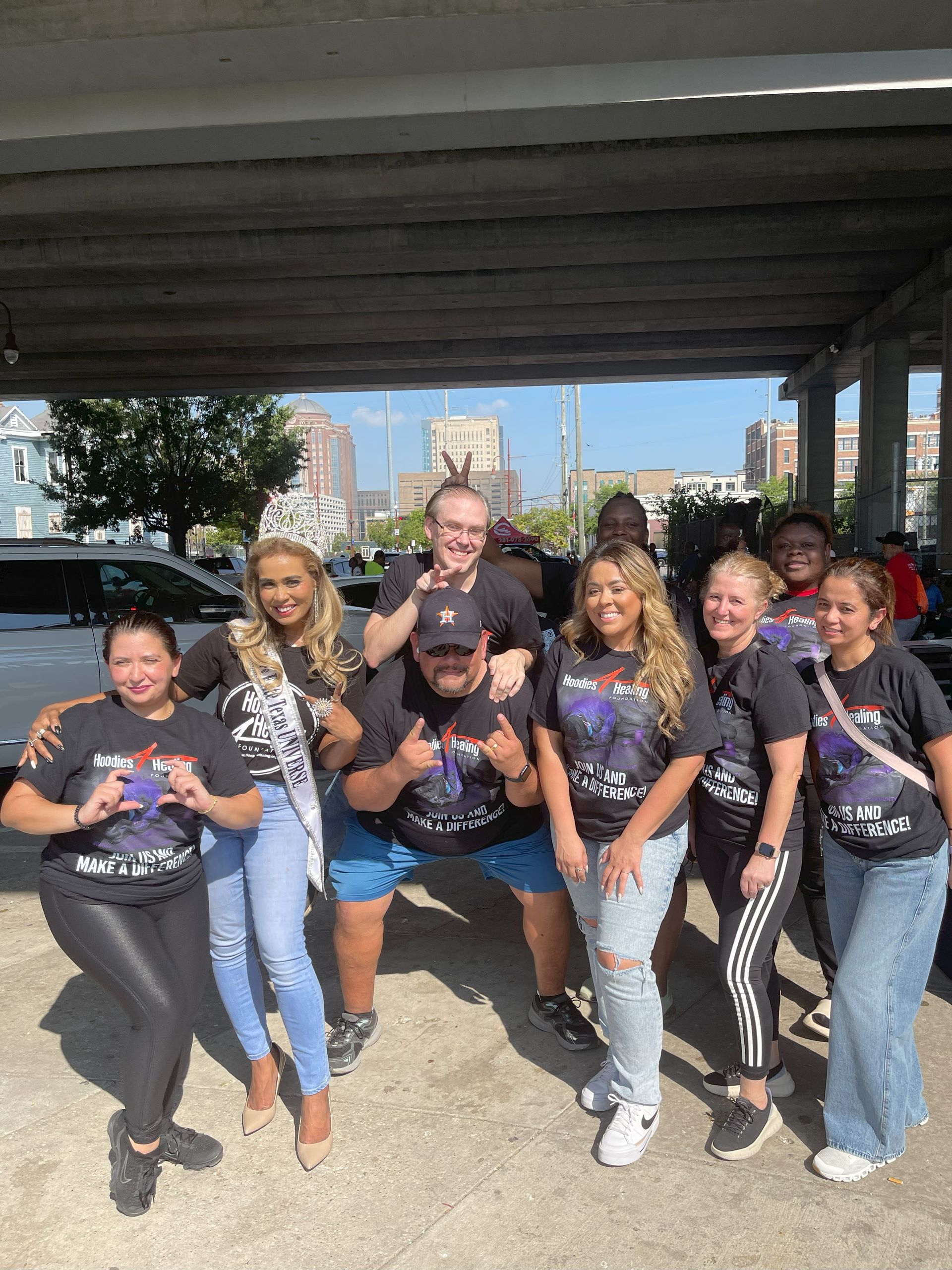 A group of people are posing for a picture under a bridge.
