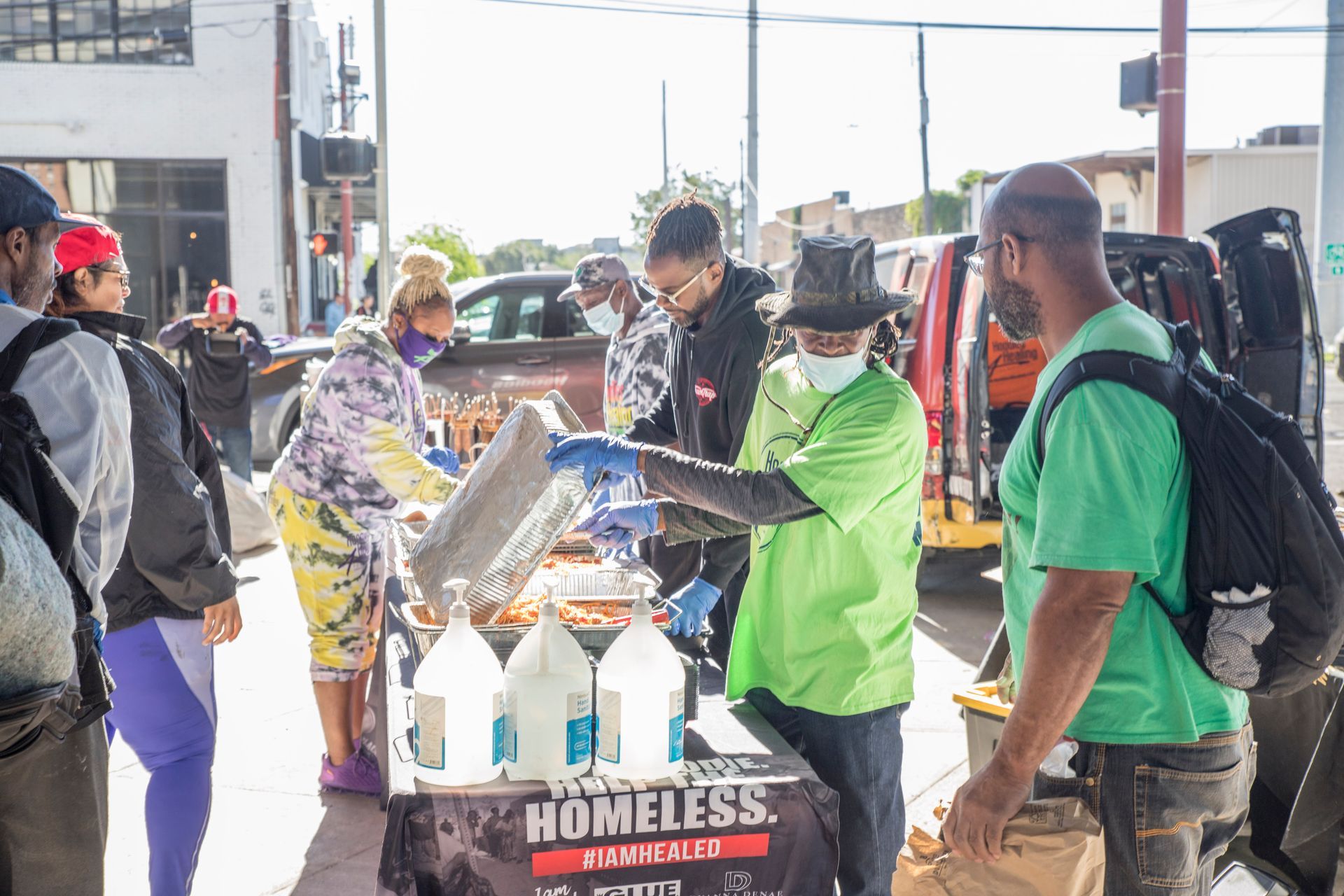 A group of people are standing around a table with bottles of water.