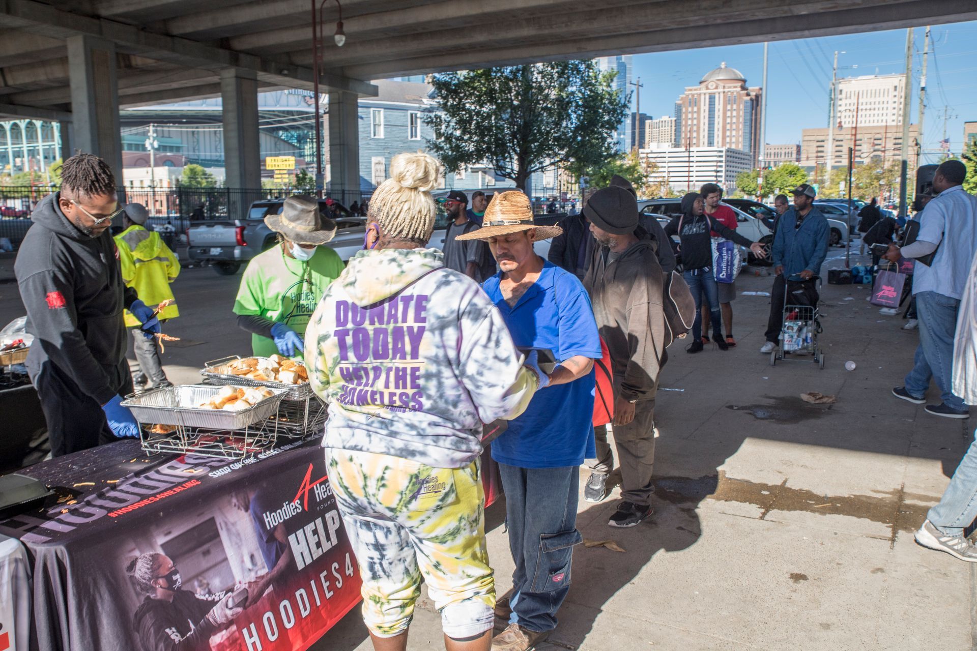 A group of people are standing around a table with a sign that says donate today.