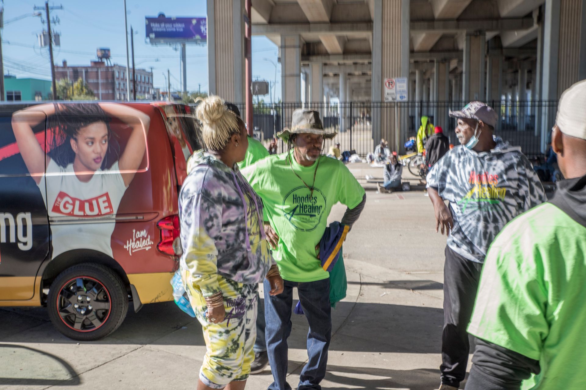 A group of people are standing in front of a van.
