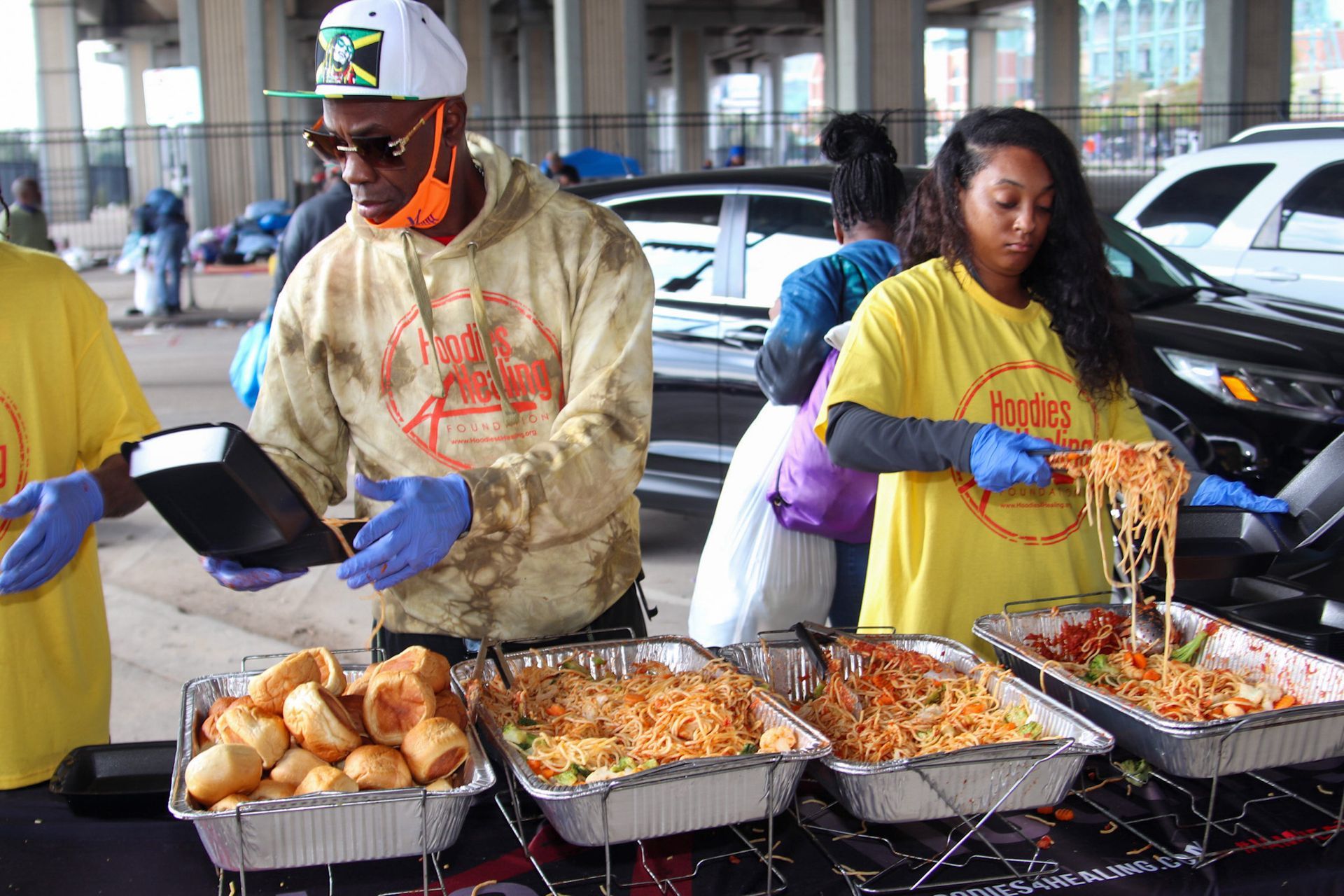 A group of people are standing around a table serving food.