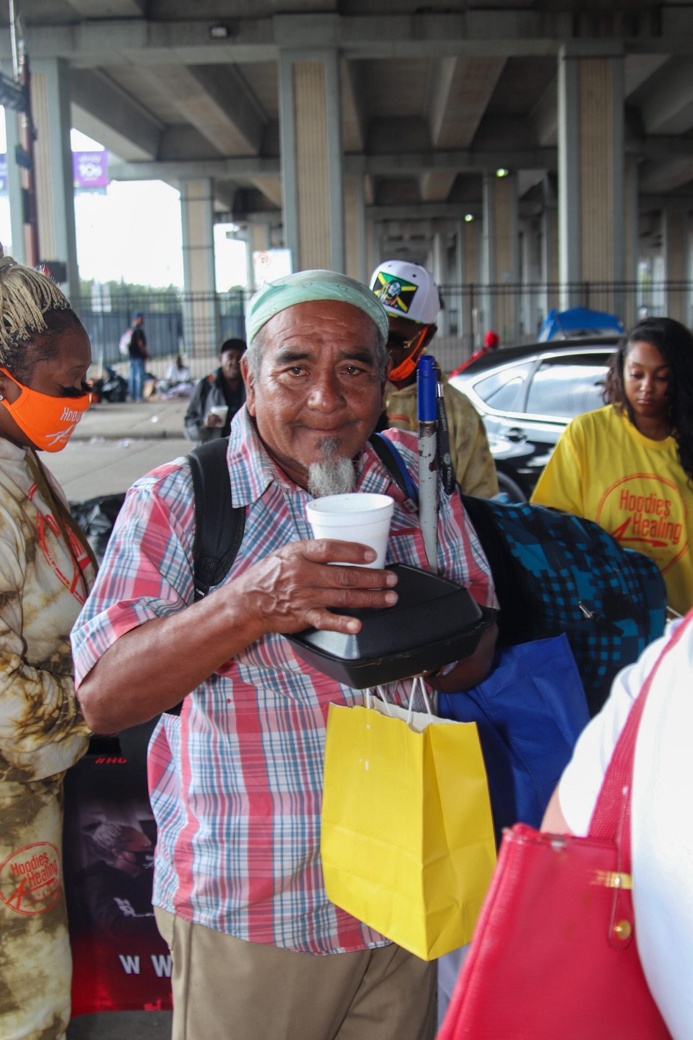 A man in a plaid shirt is holding a cup in his hand.