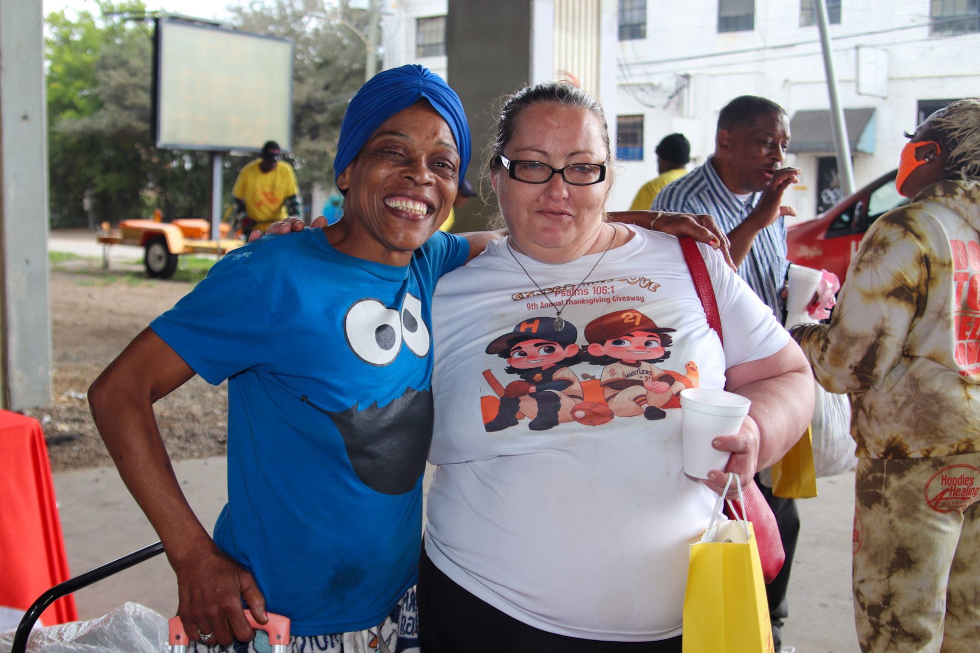 Two women posing for a picture with one wearing a cookie monster shirt