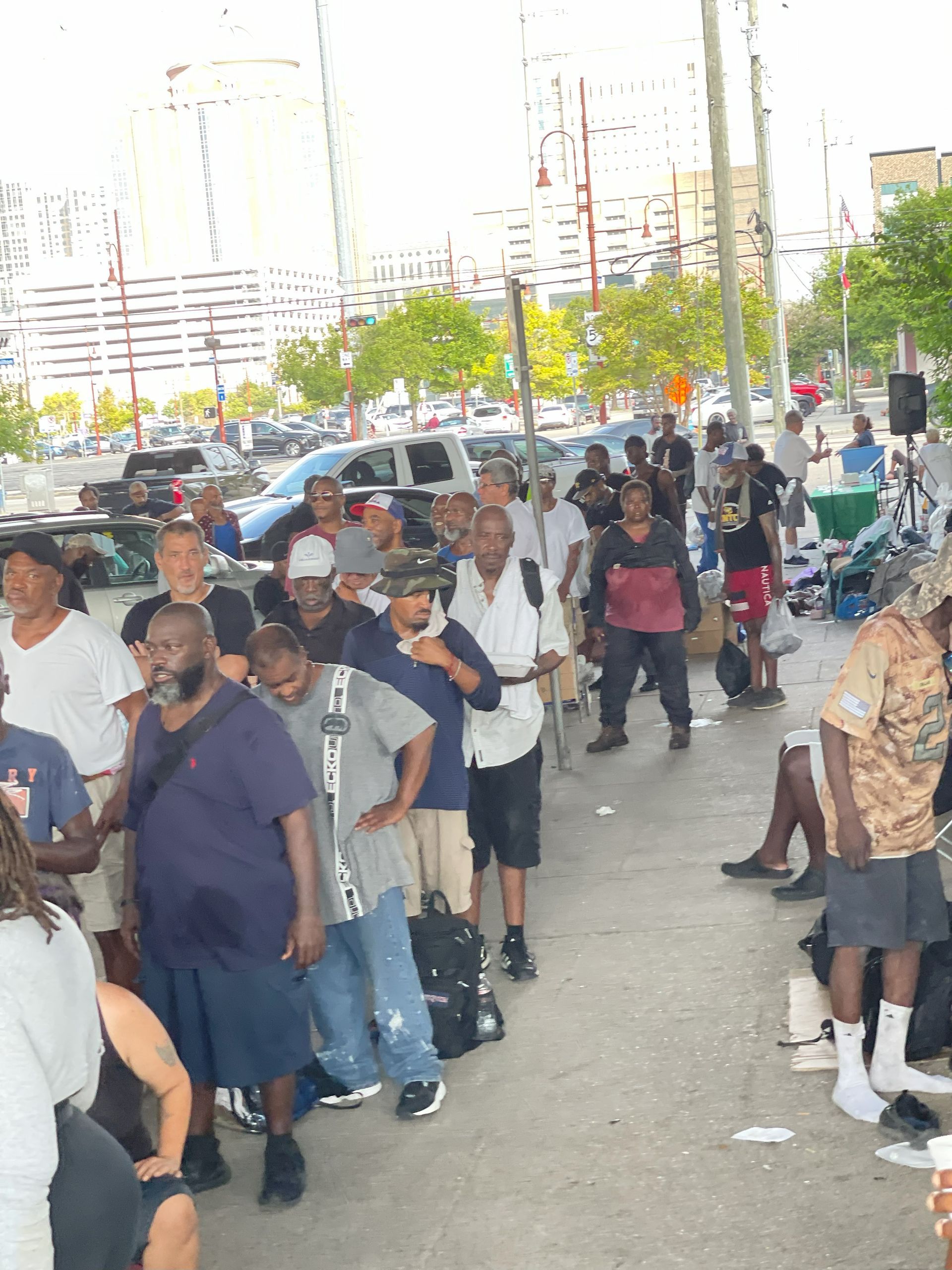 A group of people are standing in a line on a sidewalk