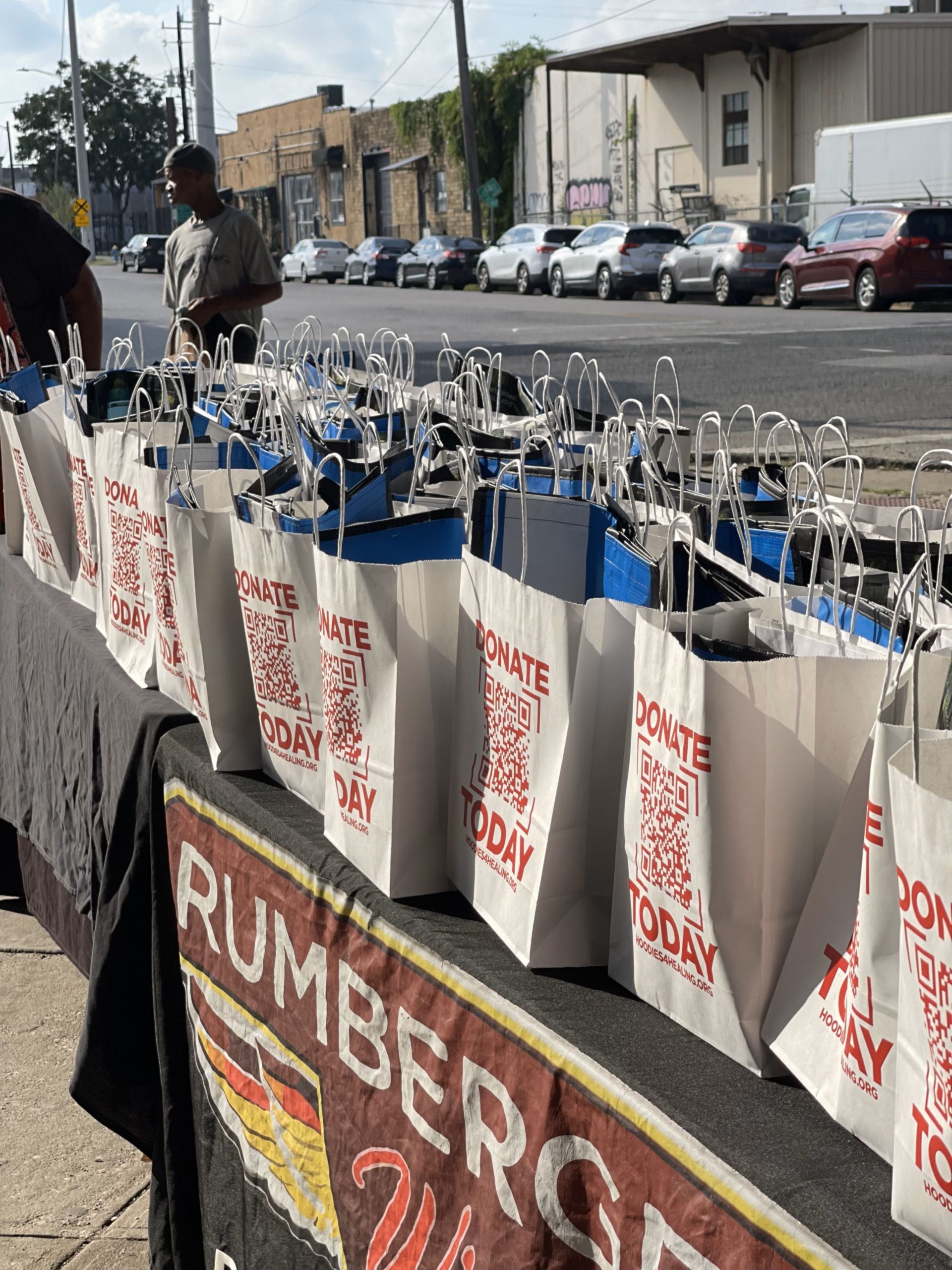 A row of shopping bags are lined up on a table.