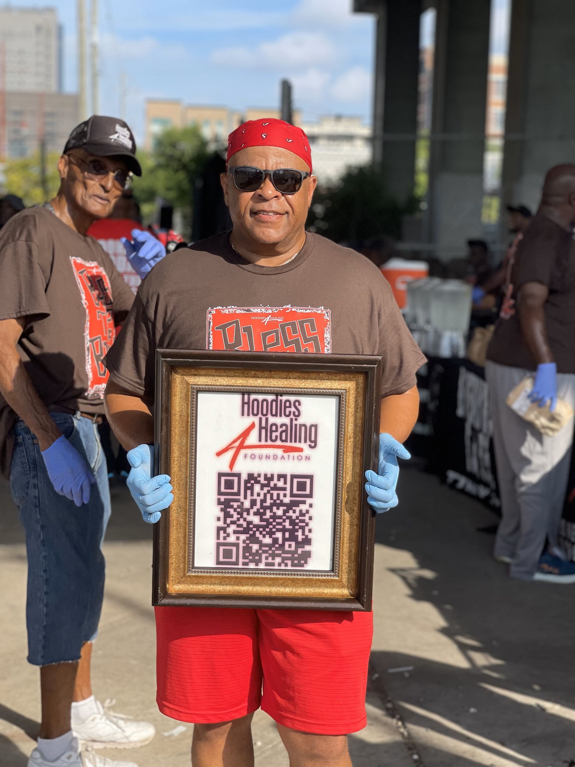 A man is holding a framed picture with a qr code on it.