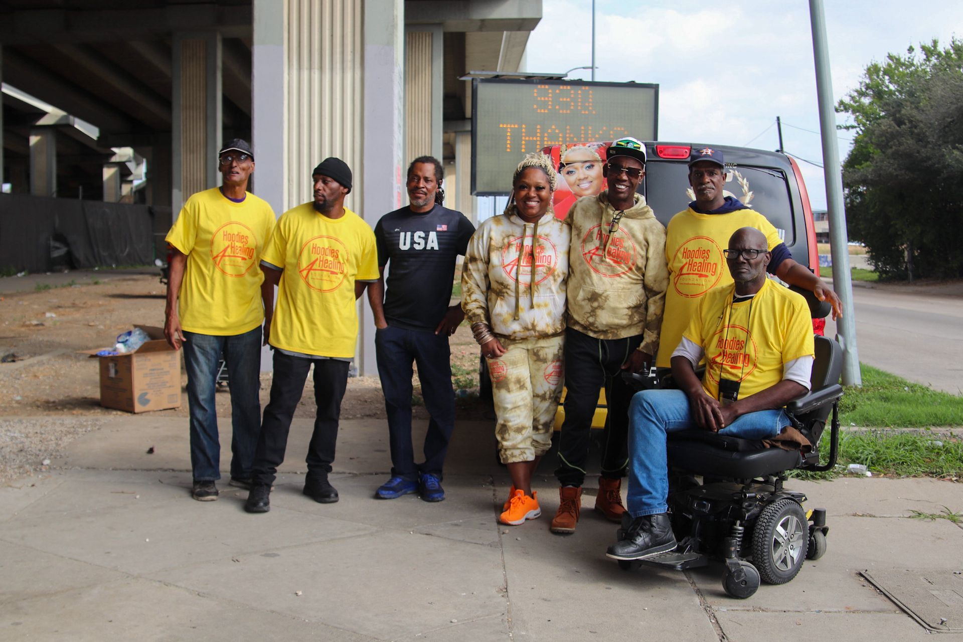 A group of people posing for a picture with one man in a wheelchair