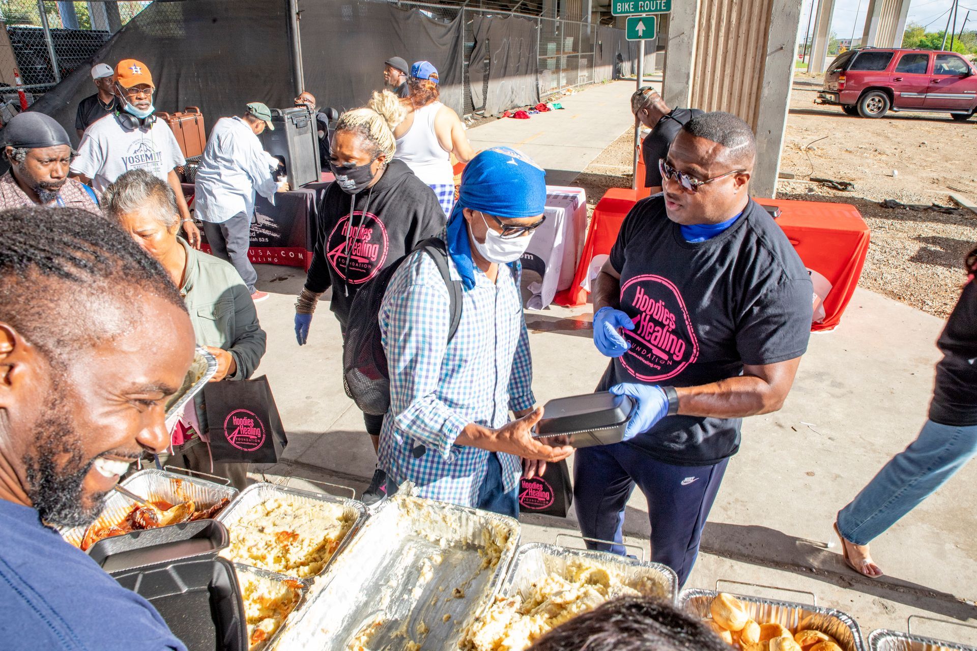 A group of people are standing around a table eating food.