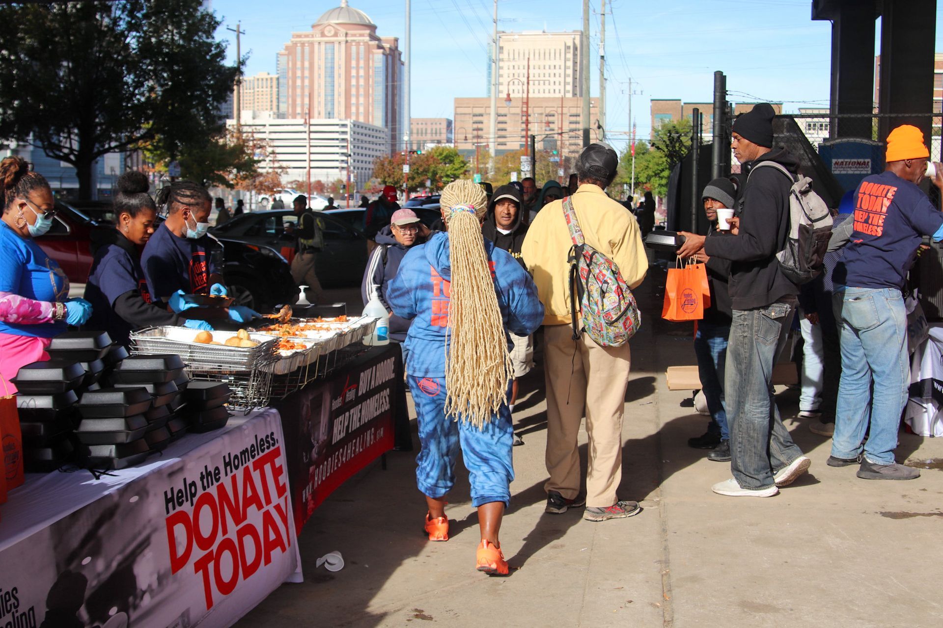 A group of people standing around a table that says donate today