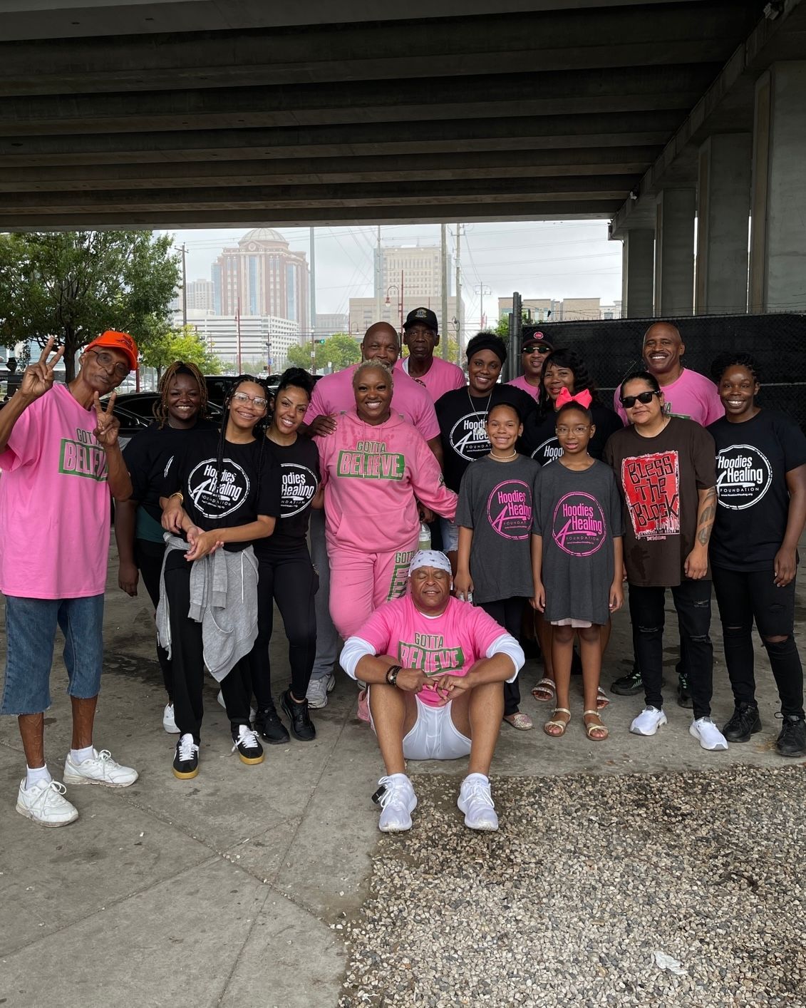A group of people are posing for a picture under a bridge.