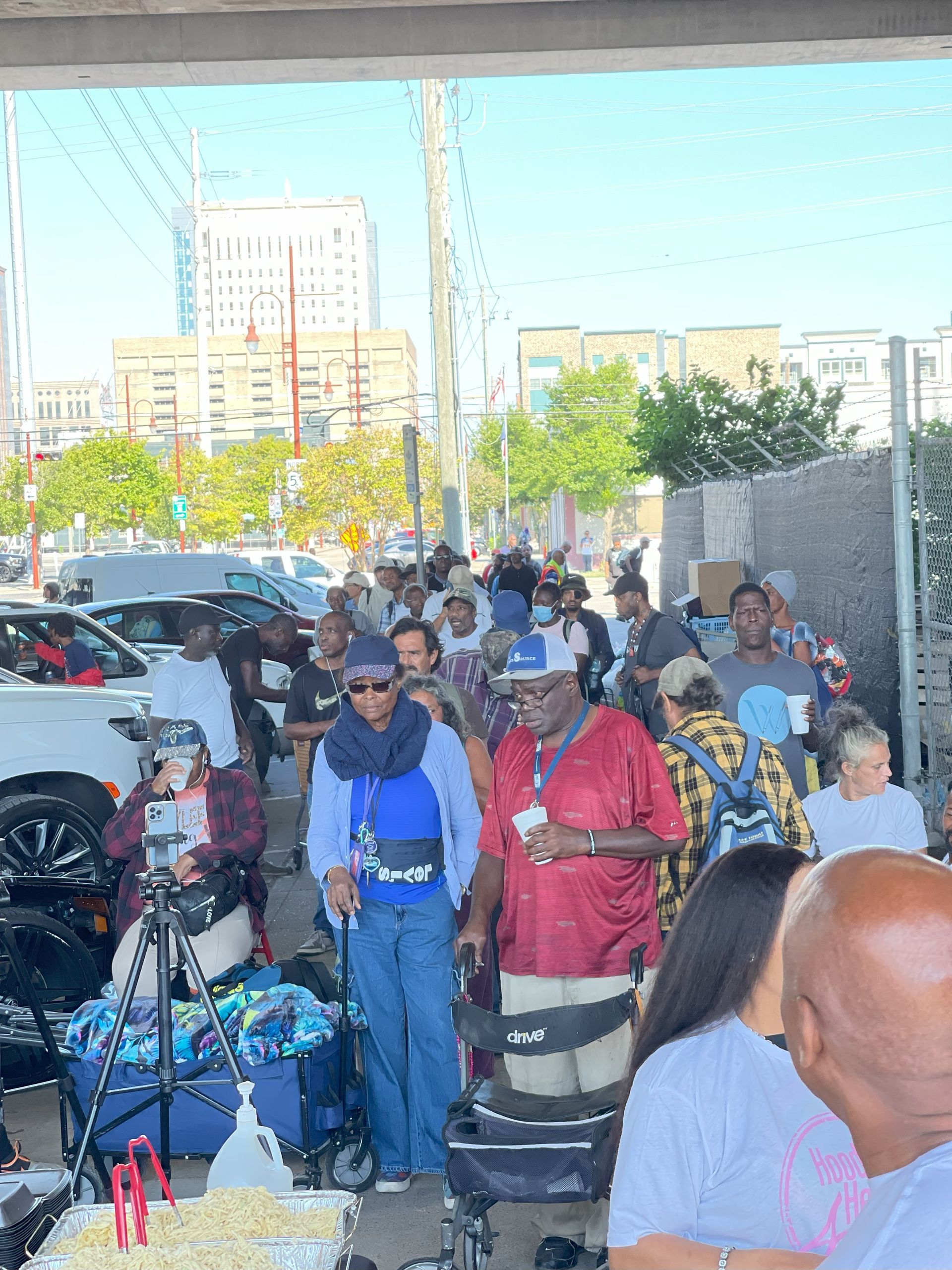 A large group of people are standing in a parking lot.