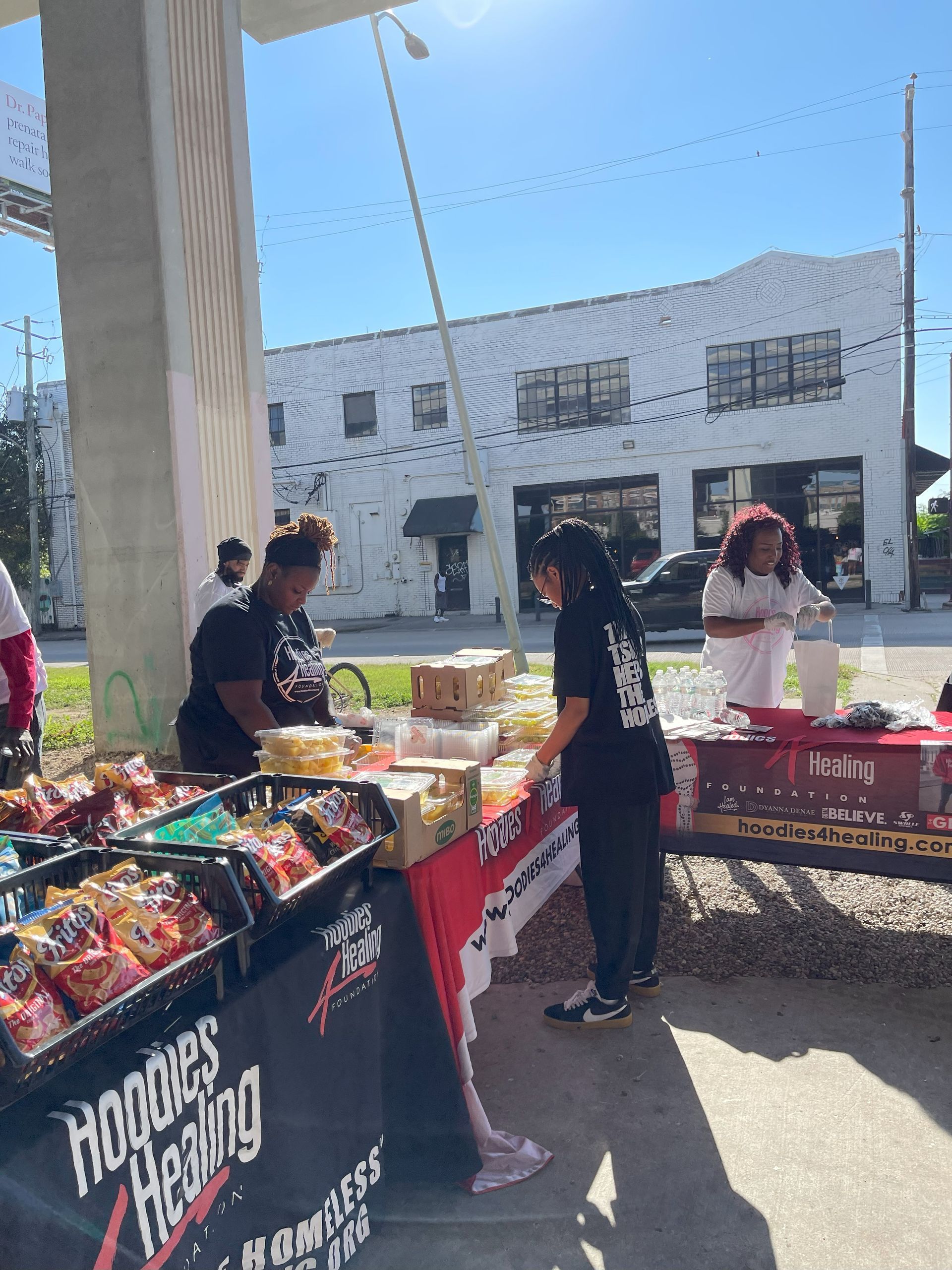 A group of people are standing around a table selling food.