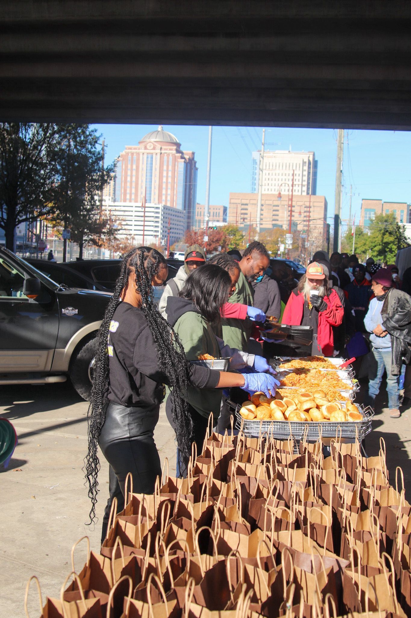 A group of people are standing around a table filled with food.