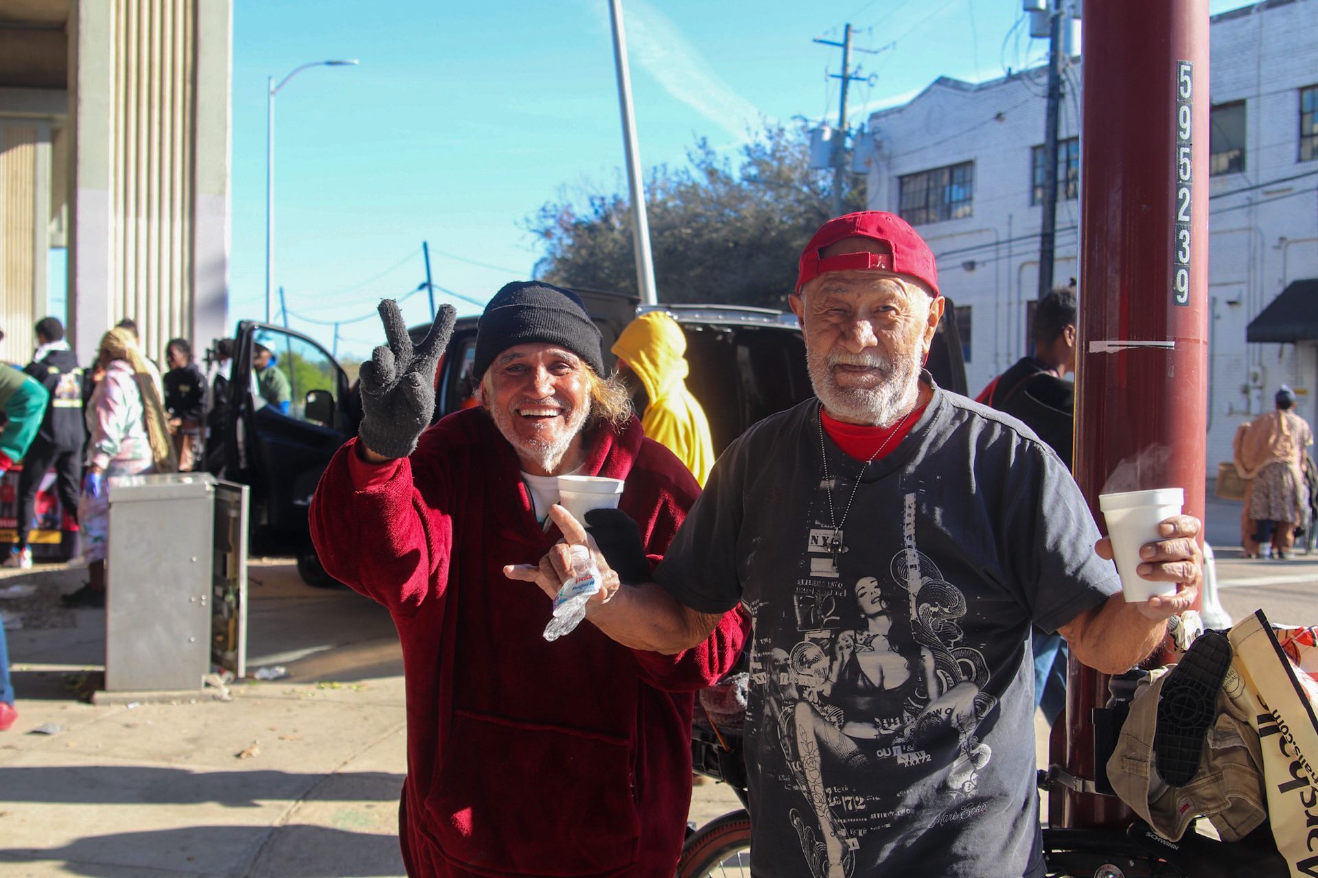 A man and a woman are standing next to each other holding cups of coffee.
